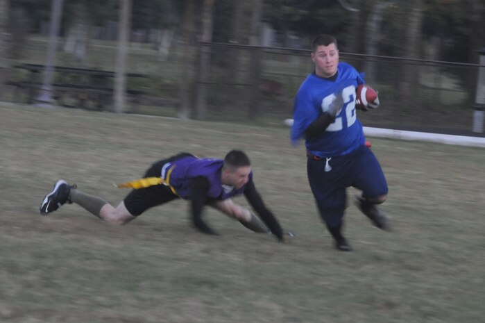 Joshua Cook removes the flag from a Coast Guard player in order to stop him from getting a first down during an intramural flag football game held here Nov. 3. The game was held between the 437th Security Forces Squadron and the Coast Guard. Cook is a member of the 437 SFS. (U.S. Air Force photo/Staff Sgt. Marie Brown)
