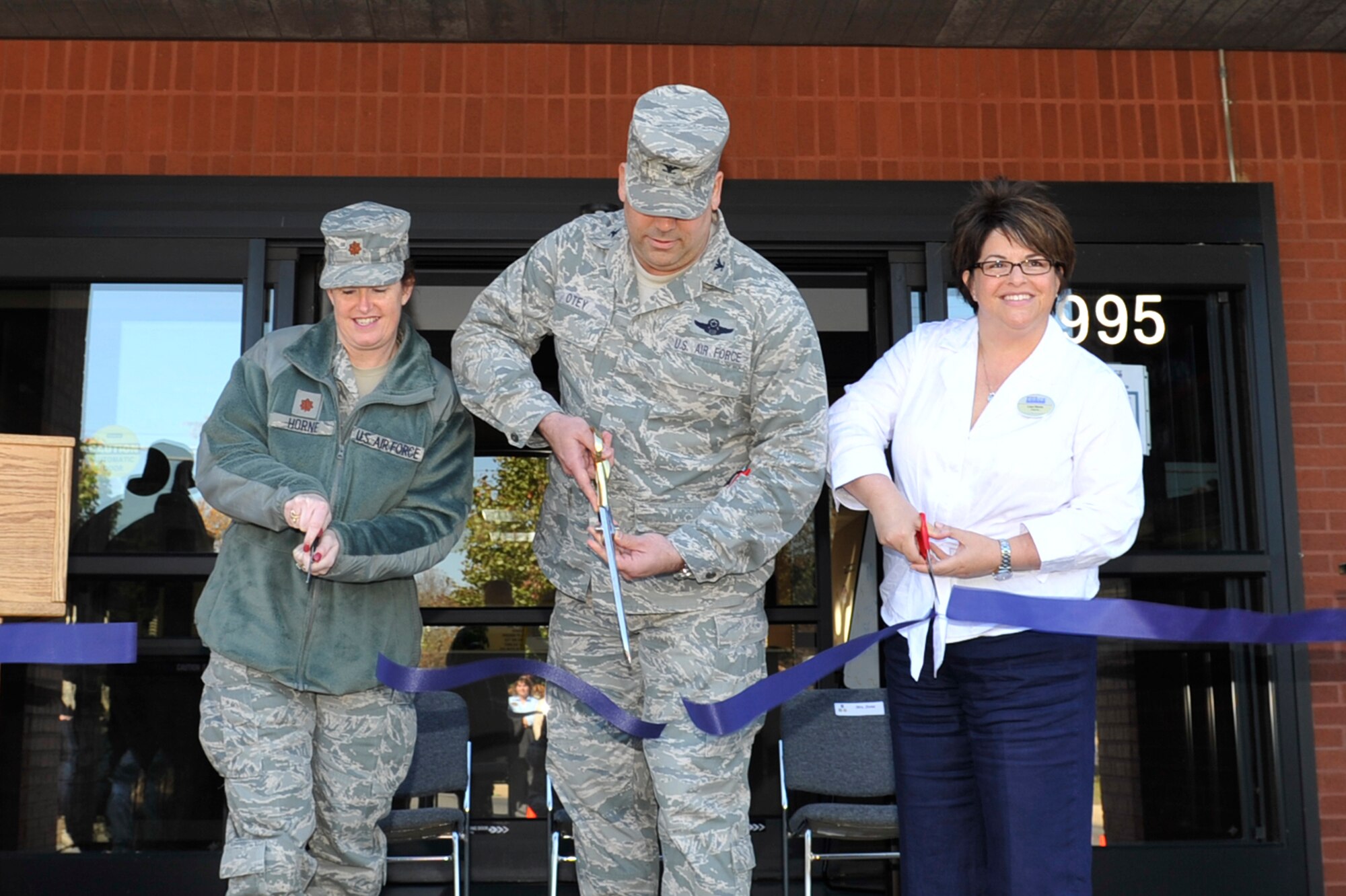 Maj. Debbie Horne, 19th Force Support Squadron commander, Col. Greg Otey, 19th Airlift Wing commander, and Lisa Stone, 19th FSS deputy commander, cut the ribbon at the opening ceremony for the teen center Nov. 3.  The teen center was established to give the base’s youth, many of whom have a deployed parent, a place to get away and gather with other teens to socialize, relax and bond. (U.S. Air Force photo by Lausanne Pacheco)