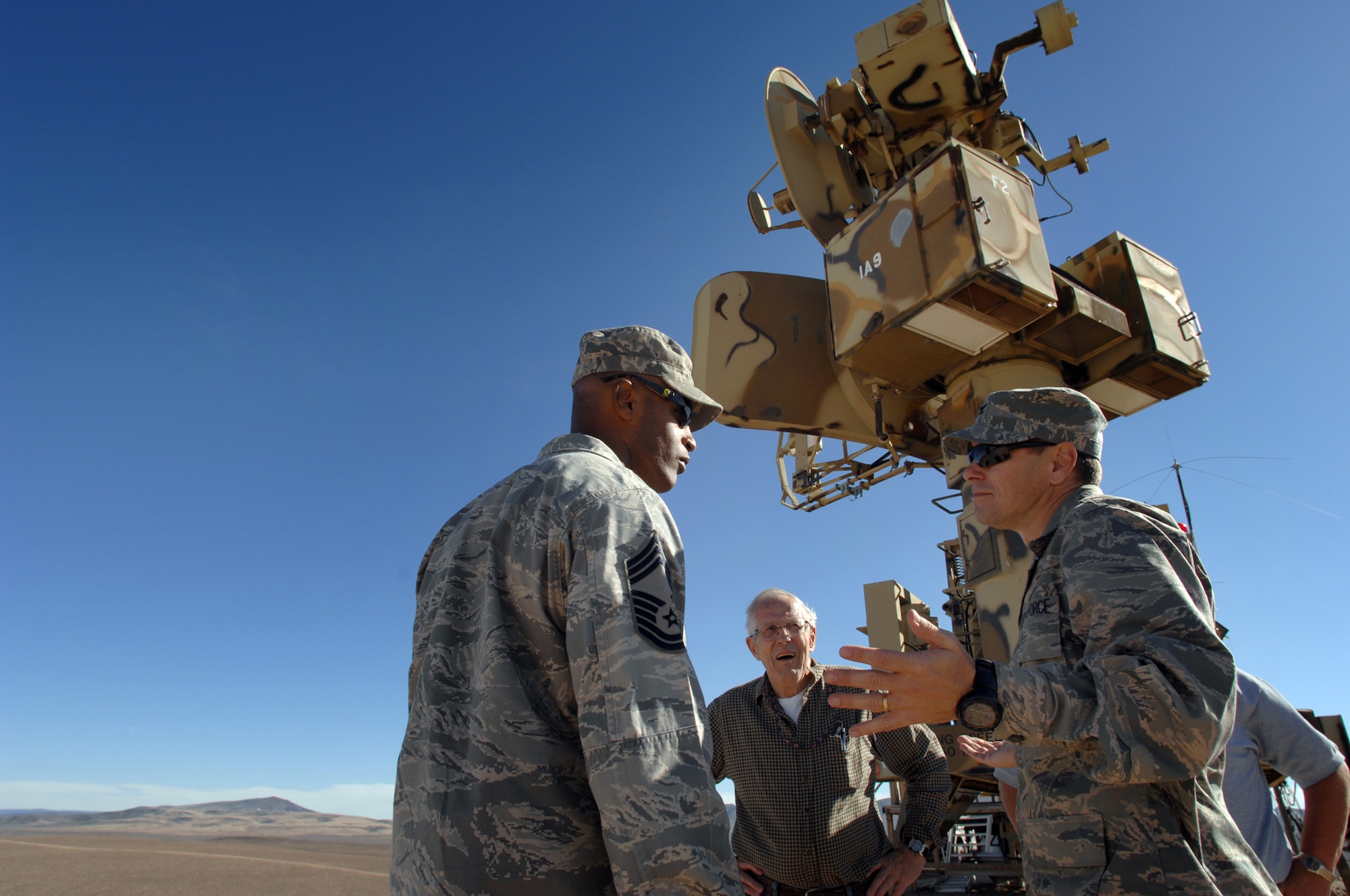 NEVADA TEST and TRAINING RANGE, Nev. -- Col. John Montgomery 98th Range Wing commander and Chief Master Sgt. Mark Darden 98th Range Wing superintendent greet Gene Verratti, a NTTR threat system operator of more than 30 years, outside the SA-6 threat system simulator on the Tolicha Peak Electronic Combat Range Oct. 26. The Nevada Test and Training Range accounts for 2.9 million acres of land and 12,000 square miles of airspace in Nev.. 
(U.S. Air Force photo by Tech. Sgt. Michael R. Holzworth)