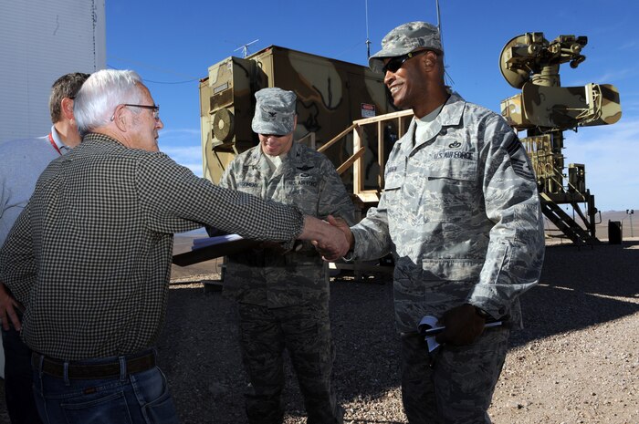 NEVADA TEST and TRAINING RANGE, Nev. -- Col. John Montgomery 98th Range Wing, commander and Chief Master Sgt. Mark Darden 98th Range Wing, superintendent greet Gene Verratti, a NTTR threat systems operator of more than 30 years, outside the SA-6 threat system simulator on the Tolicha Peak Electronic Combat Range Oct. 26. The Nevada Test and Training Range accounts for 2.9 million acres of land and 12,000 square miles of airspace in Nev.(U.S. Air Force photo by Tech. Sgt. Michael R. Holzworth)