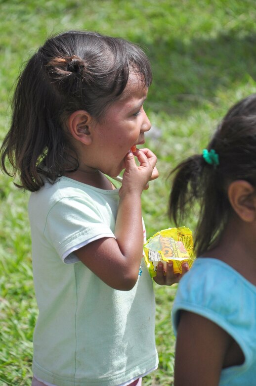 SOTO CANO AIR BASE, Honduras – A child of El Ciruelo, a remote mountain village near Comayagua, Honduras, eats a piece of candy Oct 31. Eighty-one volunteers from Joint Task Force-Bravo hiked more than five miles up and down a rocky, mountain road to deliver food to the remote village. The volunteers carried a total of 122 bags of food, equaling 2,684 pounds. Each bag of food was intended to go to one of the families of this poor mountain village, and included vegetable oil, ketchup, pasta, a couple cans of sardines and bags of sugar, rice, flour and beans (U.S. Air Force photo/Staff Sgt. Chad Thompson).