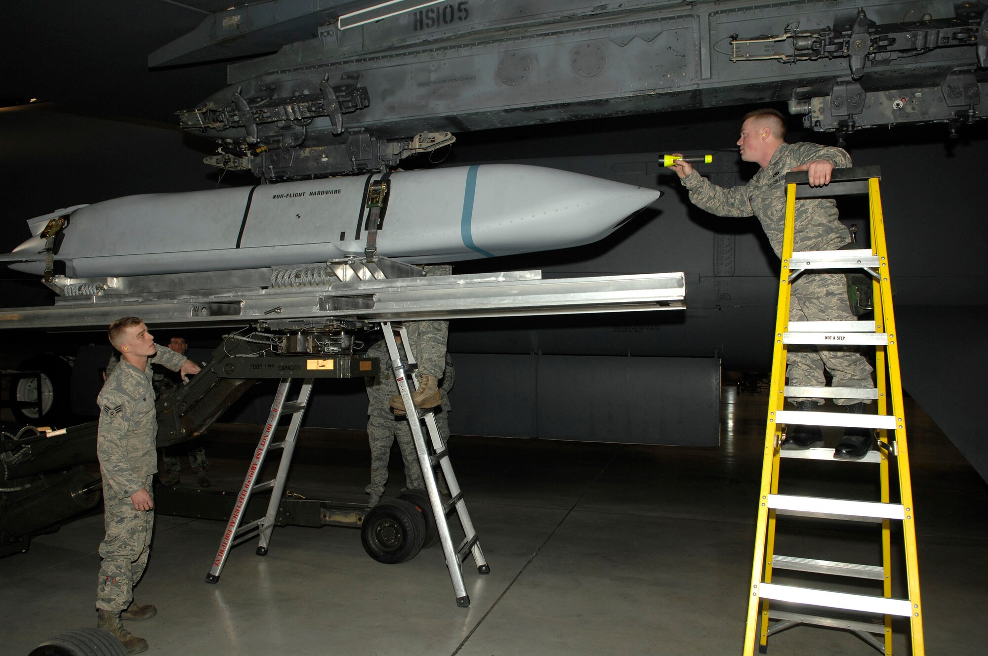 MINOT AIR FORCE BASE, N.D. -- Senior Airman Lewis Swartz calls out commands to Senior Airman Joshua Nix, both members of the 5th Aircraft Maintenance Squadron weapons load crew, to line up an AGM-158 joint air to surface standoff missile during a load crew competition here, Oct. 30. Each load crew team consists of four Airmen who are evaluated every month on how well they load different types of weapons. (U.S. Air Force photo by Senior Airman Matthew Smith)