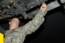 MINOT AIR FORCE BASE, N.D. – Senior Airman Lewis Swartz, 5th Aircraft Maintenance Squadron weapons load crew member, performs a bomb rack preparation on a B-52H Stratofortress during a load crew competition here, Oct. 30. Each load crew team consists of four Airmen who are evaluated every month on how well they load different types of weapons. (U.S. Air Force photo by Senior Airman Matthew Smith)