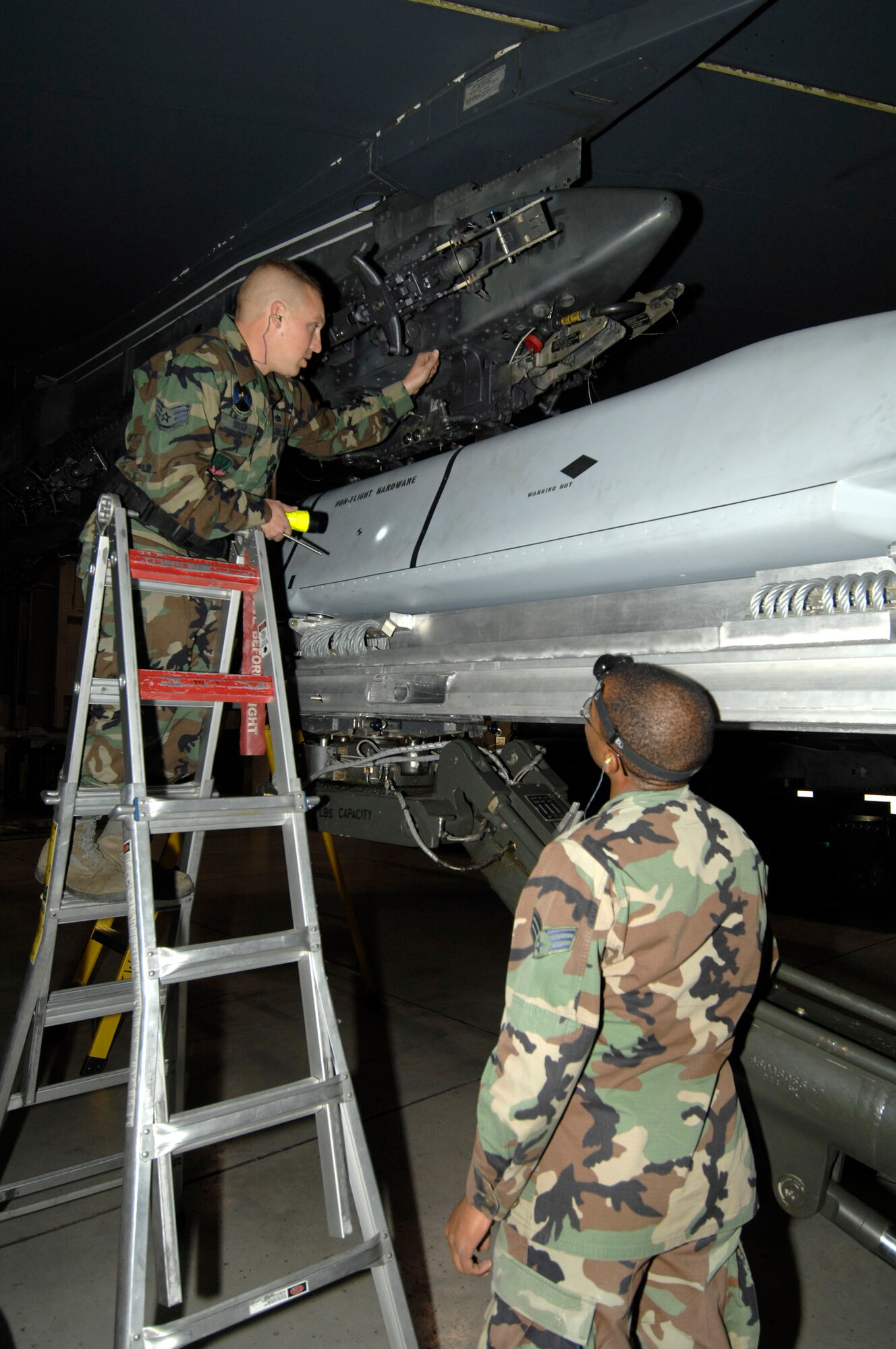 MINOT AIR FORCE BASE, N.D. -- Staff Sgt. Cameron Sogge calls out commands to Senior Airman Devonde Reuben, both members of the 5th Aircraft Maintenance Squadron weapons load crew, to line up an AGM-158 joint air to surface standoff missile during a load crew competition here, Oct. 30. Each load crew team consists of four Airmen who are evaluated every month on how well they load different types of weapons. (U.S. Air Force photo by Senior Airman Matthew Smith)
