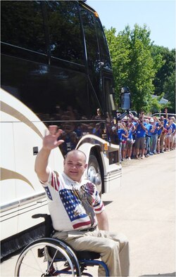 James Terpenning, an Aeronautical Systems Center information technology specialist, waves to thousands of volunteers and onlookers after seeing his new home unveiled as part of the television show 'Extreme Makeover: Home Edition' on Aug. 6, 2009. The episode featuring the Terpenning family will air Nov. 8 on ABC at 8 p.m./7 p.m. Central time. (U.S. Air Force photo/Ron Fry) 