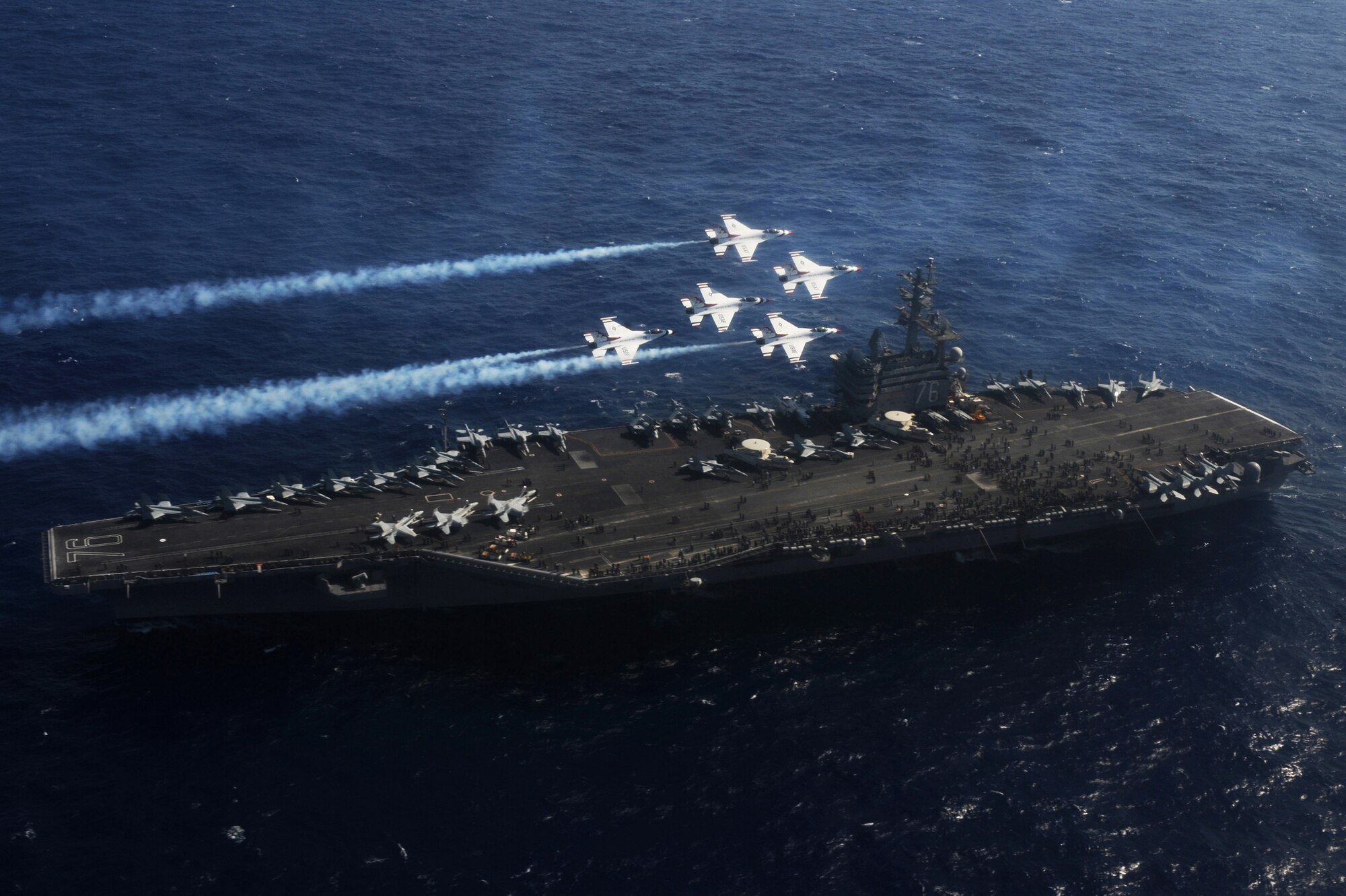 The U.S. Air Force Thunderbird "stinger" formation flies over the U.S.S. Ronald Reagan, a Nimitz-class nuclear-powered supercarrier in the service of the U. S. Navy, prior to beginning their practice at Andersen Air Force Base, Guam, Oct. 6.  (U.S. Air Force photo by Staff Sgt. Kristi Machado)