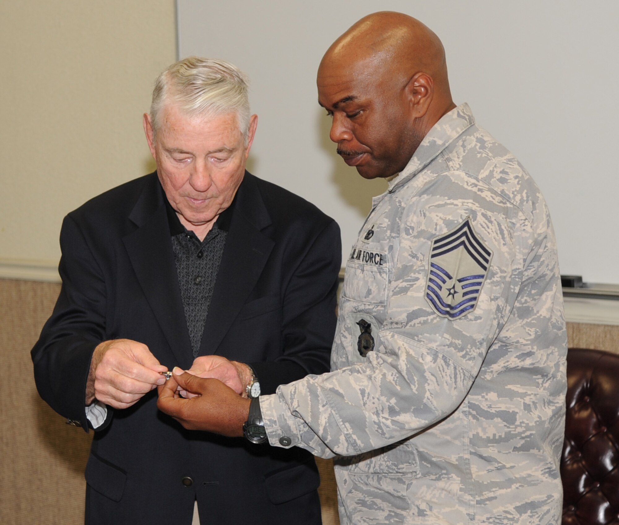 Barksdale AFB, La. - Chief Master Sgt. of the Air Force #5 Robert Gaylor receives a coin by Chief Master Sgt. Calvin Howell, 2d Security Forces during a visit to the 2d SFS hanger Oct. 28. Chief Gaylor originally was military police during his Air Force career. (U.S. Air Force photo by Senior Airman Alexandra Longfellow) (RELEASED)