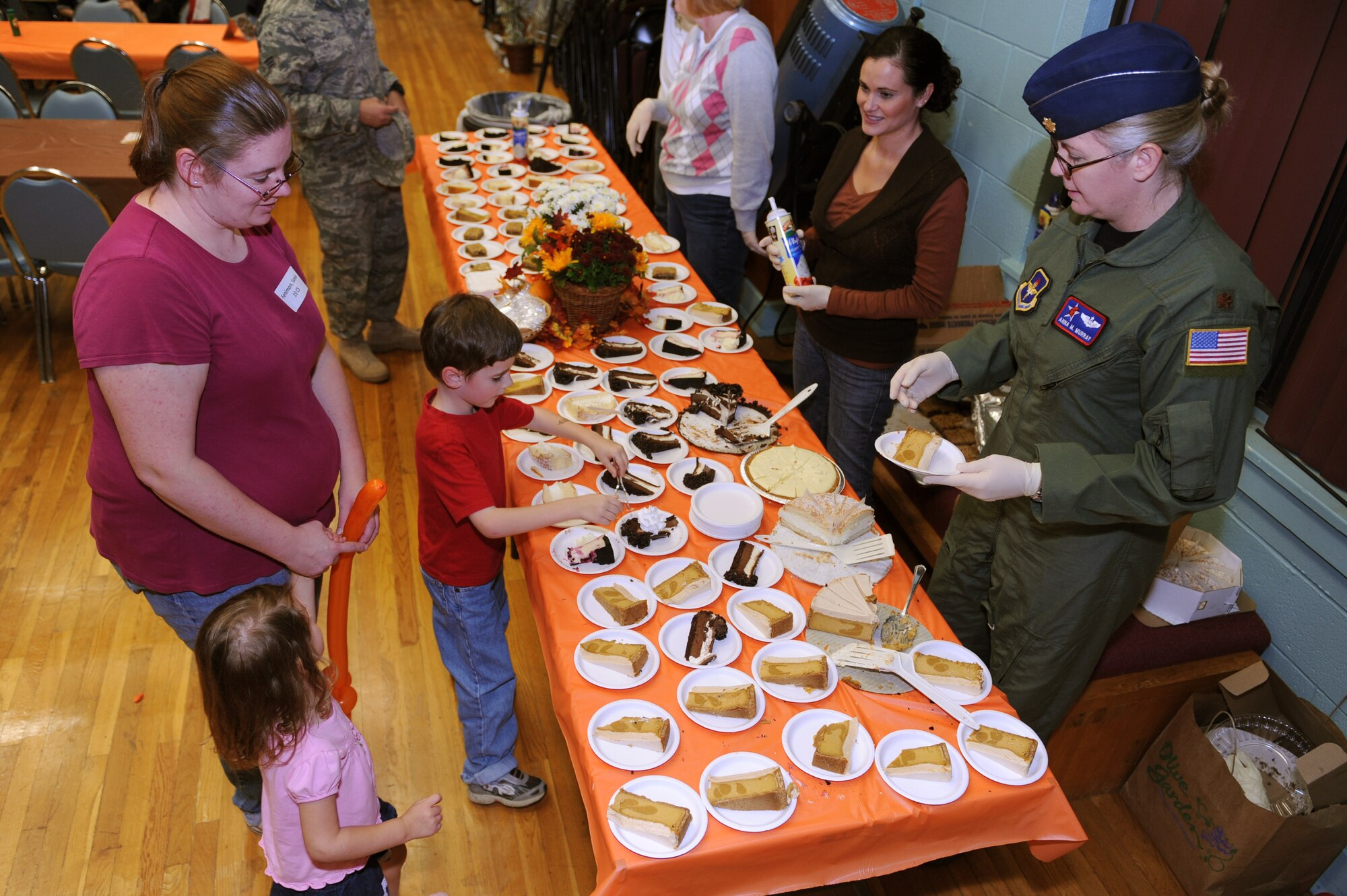 Maj. Anna Murray, 714th Training Squadron flight commander, serves desserts to Sonia Fenimore and her children during the deployed spouses dinner Nov. 3 on base. The quarterly deployed spouses dinner is a way for the base to say thank you as well as support spouses of deployed members. For more information about services for spouses of deployed members, call the Airman and Family Readiness Center at 987-6801. (U.S. Air Force photo by Senior Airman Jim Araos)