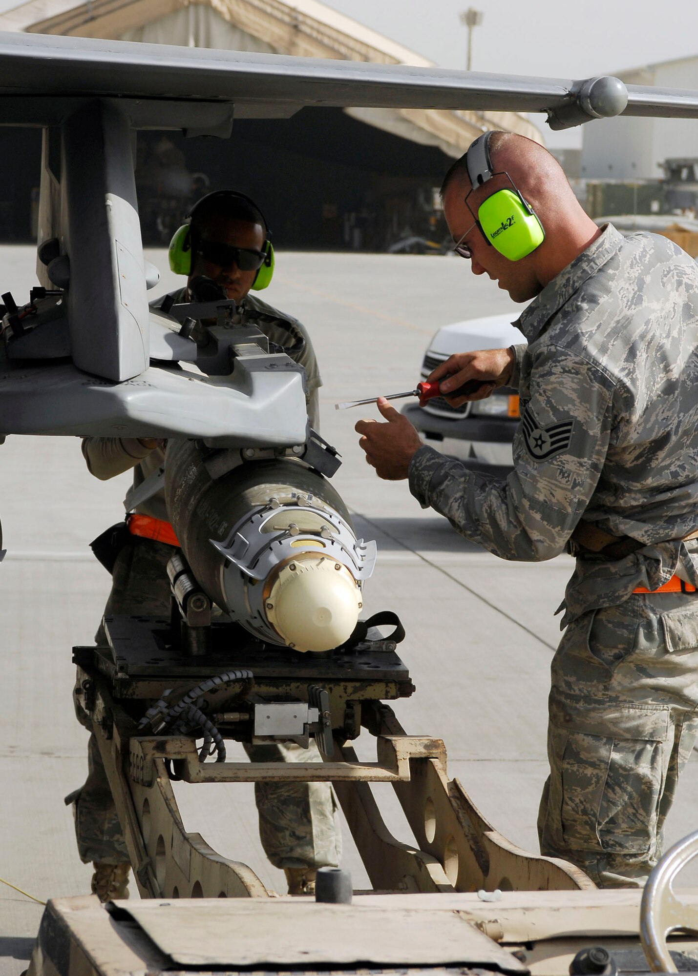 BAGRAM AIRFIELD, Afghanistan -- Staff Sgt. Jason Tremmel (right) secures a bomb to the F-16 Fighting Falcon while Airman First Class Keith Tunstall (left) keeps the bomb stable Nov. 4, 2009.  Both Airmen are weapons-load crew members from the 455th Expeditionary Aircraft Maintenance Squadron.  Sergeant Tremmel hails from Duncansville, Pa.  Airman Tunstall hails from Shreveport, La.  Both Airmen are deployed from Shaw Air Force Base, N.C.  (U.S. Air Force photo/Senior Airman Felicia Juenke)
