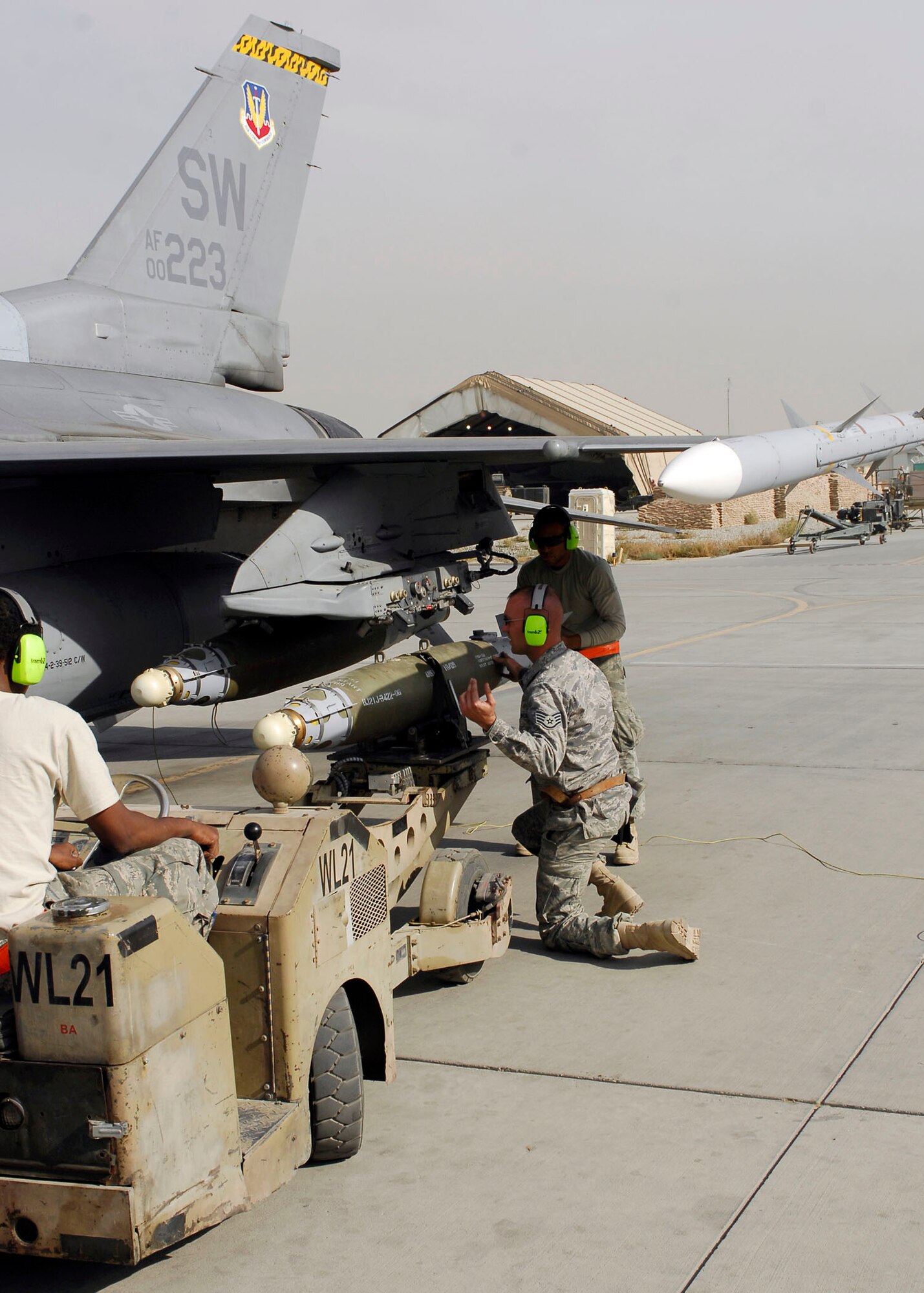 BAGRAM AIRFIELD, Afghanistan -- Staff Sgt. Jason Tremmel (middle) and Airman First Class Keith Tunstall (right) line up a bomb properly with the aircraft while Senior Airman Anthony Kilgore (left) drives the weapons loader Nov.4, 2009.  All three Airmen are weapons-load crew members from the 455th Expeditionary Aircraft Maintenance Squadron.  Sergeant Tremmel hails from Duncansville, Pa.  Airman Tunstall hails from Shreveport, La.  Airman Kilgore hails from Pomona, Calif.  All three Airmen are deployed from Shaw Air Force Base, N.C.  (U.S. Air Force photo/Senior Airman Felicia Juenke)