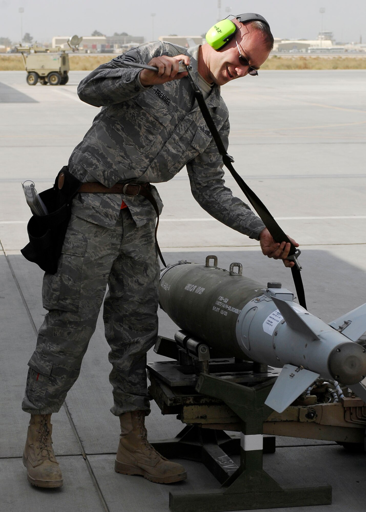 BAGRAM AIRFIELD, Afghanistan -- Staff Sgt. Jason Tremmel, a weapons-load crew chief from the 455th Expeditionary Aircraft Maintenance Squadron, straps down a bomb Nov. 4, 2009.  Sergeant Tremmel is deployed from Shaw Air Force Base, N.C., and hails from Duncansville, Pa.  (U.S. Air Force photo/Senior Airman Felicia Juenke)