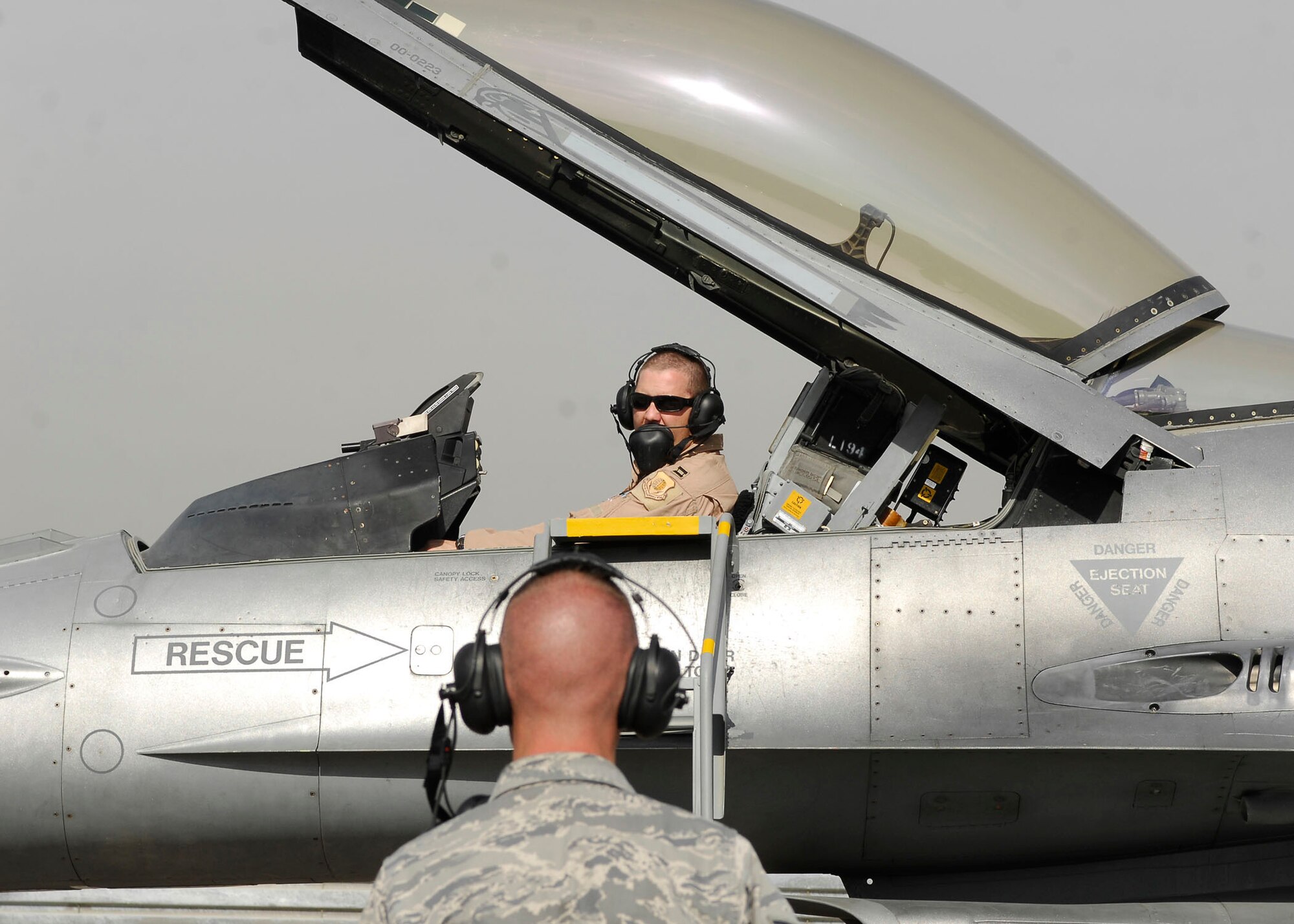 BAGRAM AIRFIELD, Afghanistan -- Staff Sgt. Jason Tremmel (on the ground), a weapons-load crew chief from the 455th Expeditionary Aircraft Maintenance Squadron, talks to Capt. Mike Watkins (in the aircraft), an F-16 Fighting Falcon pilot from the 79th Expeditionary Fighter Squadron, Nov. 4, 2009.   The maintenance Airmen work with the pilots during inspections to assure the aircraft functions properly and safely.  Sergeant Tremmel hails from Duncansville, Pa.  Capt. Watkins hails from Havasu, Ariz.  Both Airmen are deployed from Shaw Air Force Base, N.C.  (U.S. Air Force photo/Senior Airman Felicia Juenke)