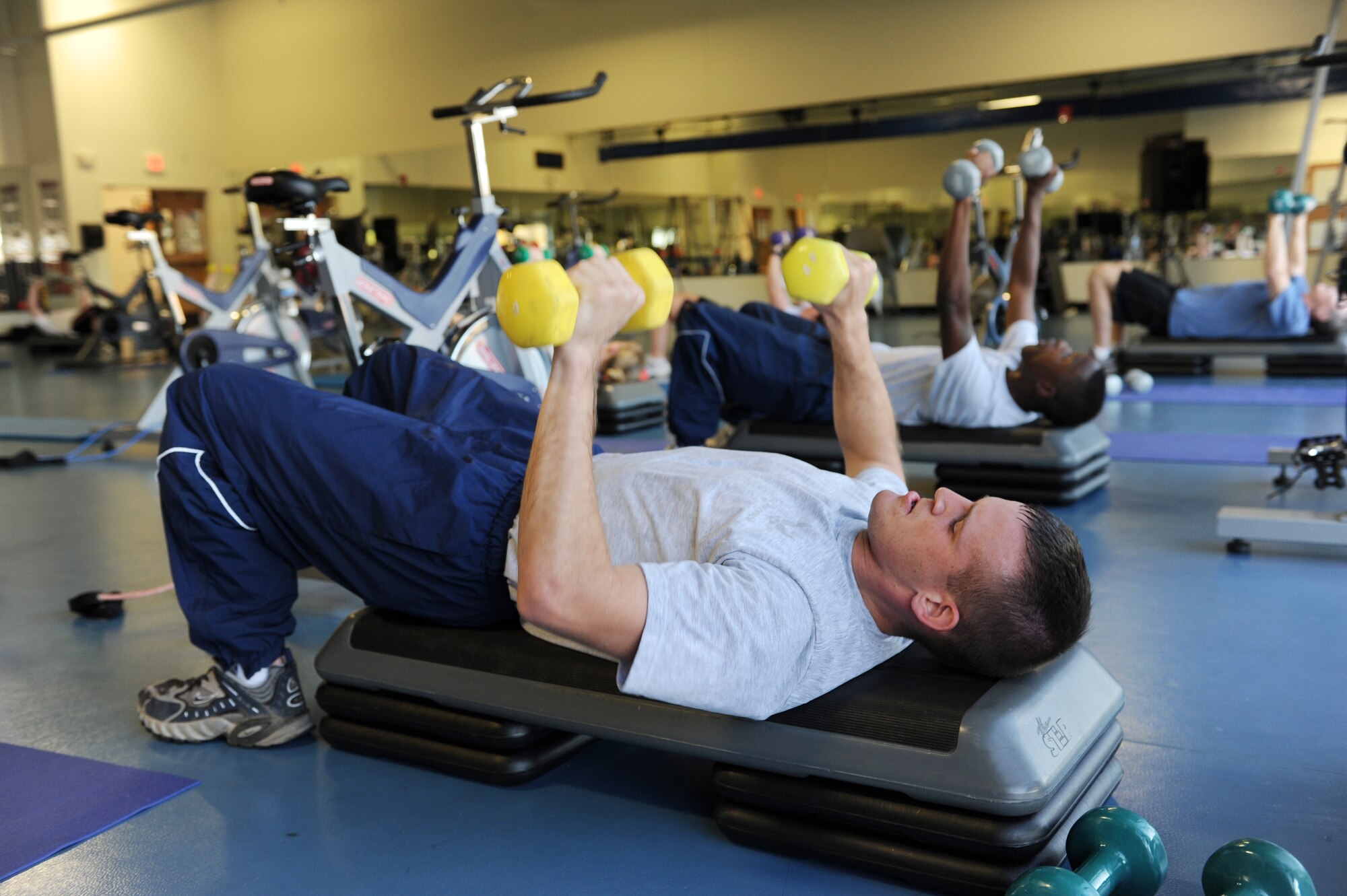 Airman First Class Matthew Kohman, 314th Maintenance Operations Squadron analyst, performs butterfly curls during the burn hour program at the fitness center on base Nov. 3. Part of the updated guidance for wear of the physical training uniform requires PT shirts to be tucked in at all times. (US Air Force photo by Senior Airman Jim Araos)