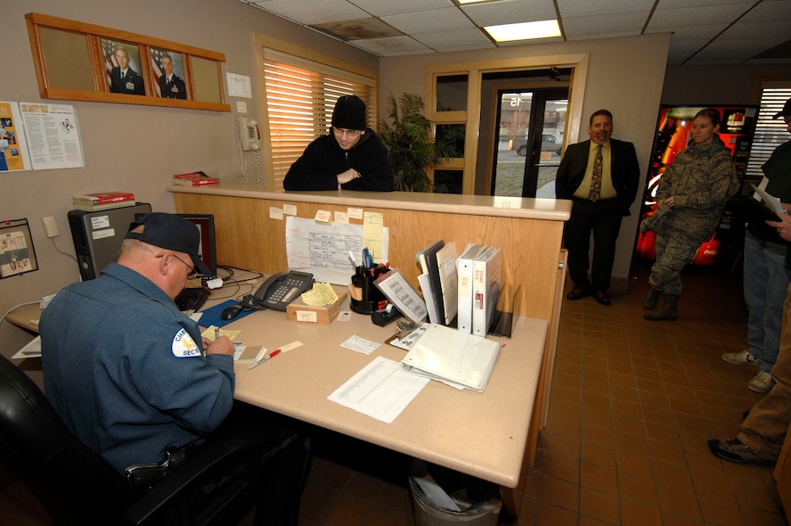 MINOT AIR FORCE BASE, N.D. -- Jeff Lynn, Minot AFB security officer, issues a visitor’s pass to Tristan Sexton, a contractor from Minot, at the base visitor’s center here, Nov. 4. Issuing visitors passes is just one of many important ways the base visitor’s center ensures Team Minot families can come together this holiday season. (U.S. Air Force photo by Senior Airman Matthew Smith)