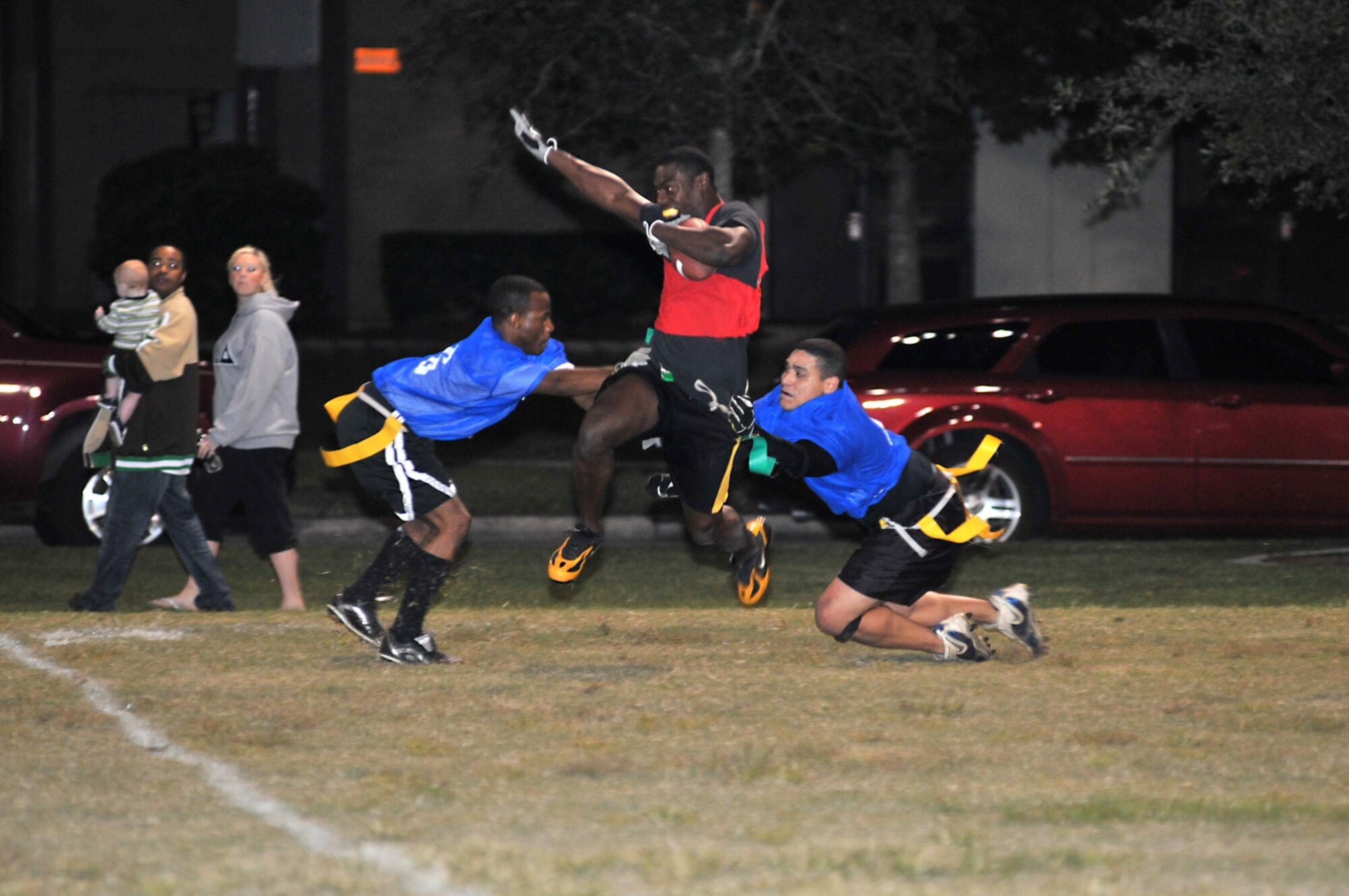 Dave Brown, left, and Robert Lagaro, right, try to strip an airborne Tony Hannah of his flag as he travels down the field during the championship game of the intramural league’s flag football postseason tournament Oct. 28.  Hannah plays for the 81st Medical Support Squadron team that won, 25-18.  Brown and Lagaro are members of the combined team from the 85th Engineering Installation Squadron and the 334th Training Squadron.  (U.S. Air Force photo by Adam Bond)