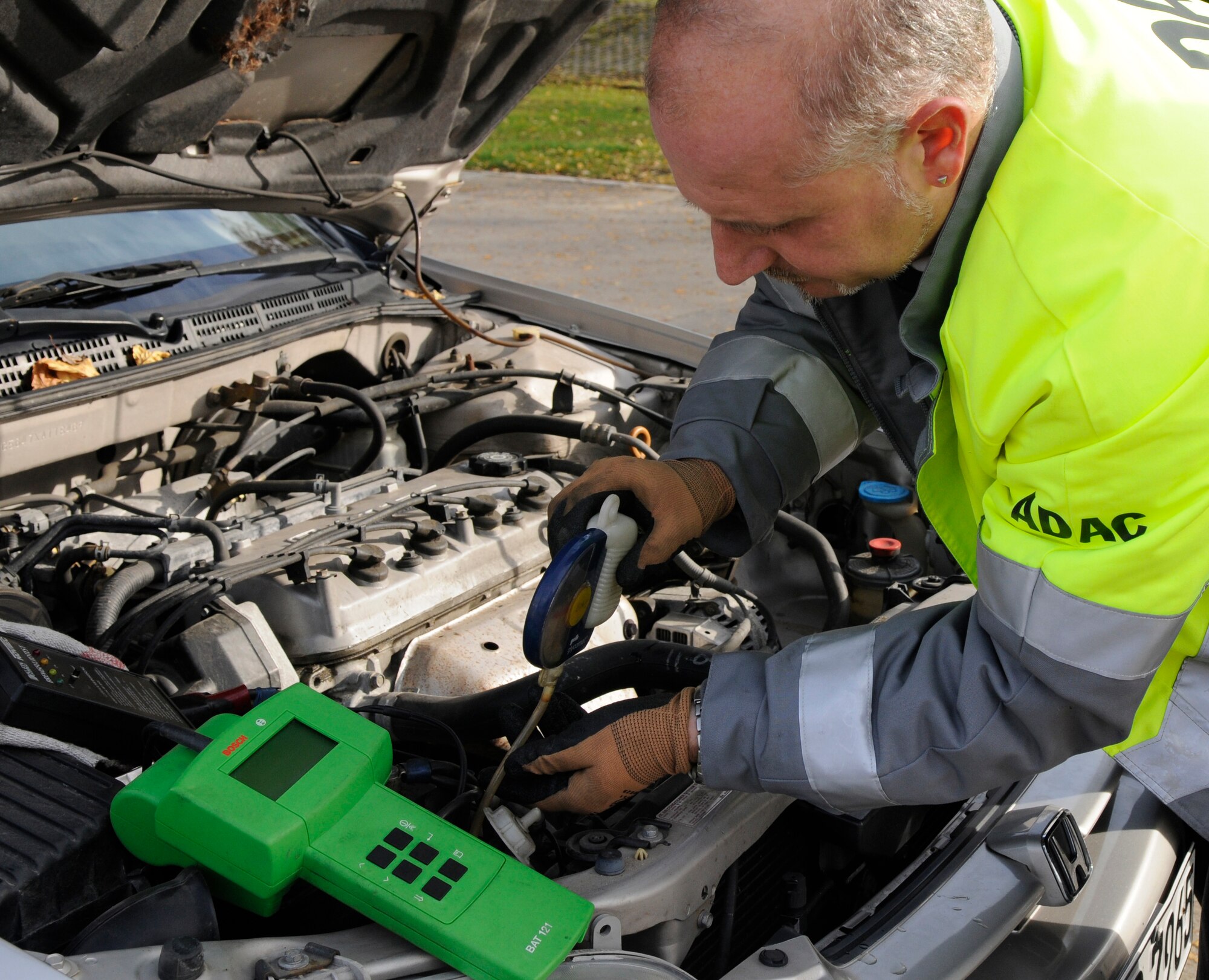 SPANGDAHLEM AIR BASE, Germany – Wolfgang Gaida, ADAC representative, checks a vehicle’s brake fluid and antifreeze conditions during a free winter vehicle check held at the Saber Driving Course Nov. 2.  The 52nd Fighter Wing Safety Office and ADAC representatives checked tires, brake fluid, lights, batteries, antifreeze conditions and performed child safety seat checks. There will be another free vehicle inspection Nov. 15. (U.S. Air Force photo/Airman 1st Class Staci Miller)