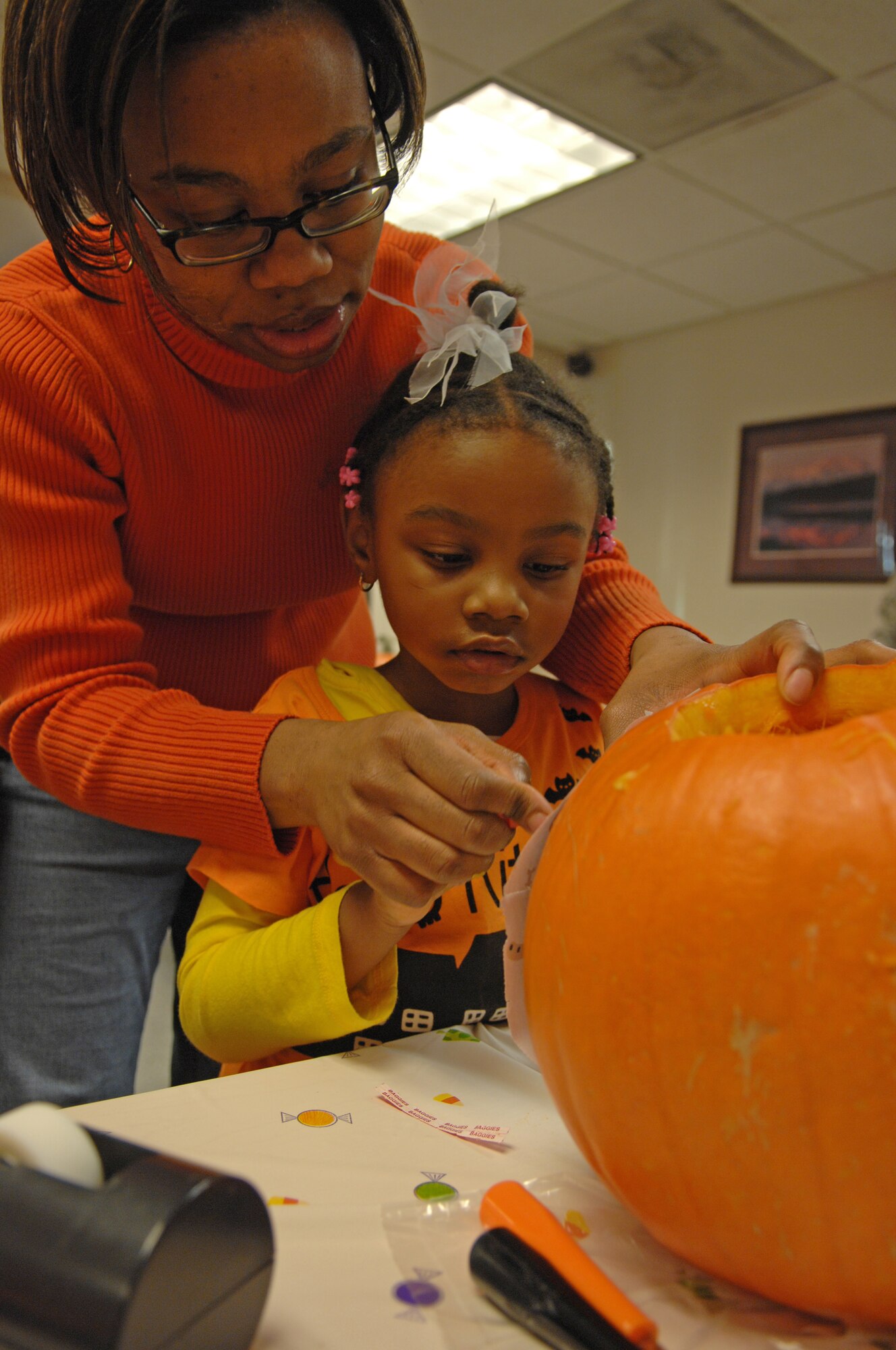 Dedra Tate helps her daughter, Sydney carve a pumpkin during a class at the Airman and Family Readiness Center Oct. 30, 2009, Eielson Air Force Base, Alaska. The pumpkin carving class is one of the many different classes the Airman and Family Readiness Center offers for Airmen and their families. Dedra and Sydney are the family of Maj. Mark Tate, 354th Logistics Readiness Squadron commander. (U.S. Air Force photo/Airman 1st Class Rachelle Coleman)