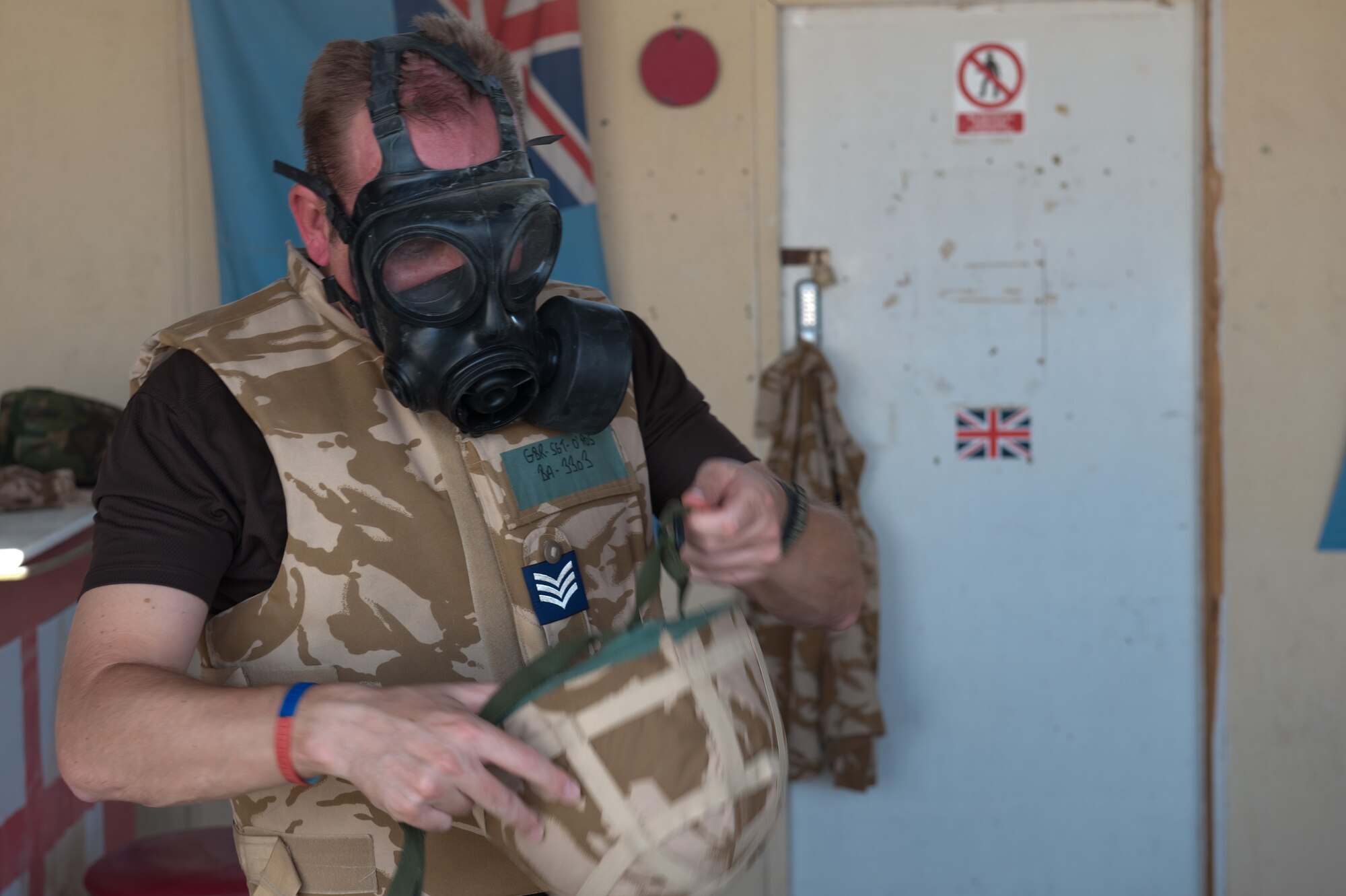 Royal Air Force Sgt. Steve Barnes, 83rd Expeditionary Air Group mechanical transport officer, dons his respirator in response to a simulated attack during a base defense exercise, Nov. 3, 2009 in Southwest Asia. Personnel assigned to the 379th Air Expeditionary Wing and base tenant units participate in exercises regularly to train on a variety of potential real-world scenarios. (U.S. Air Force Photo/Staff Sgt. Robert Barney/Released) 