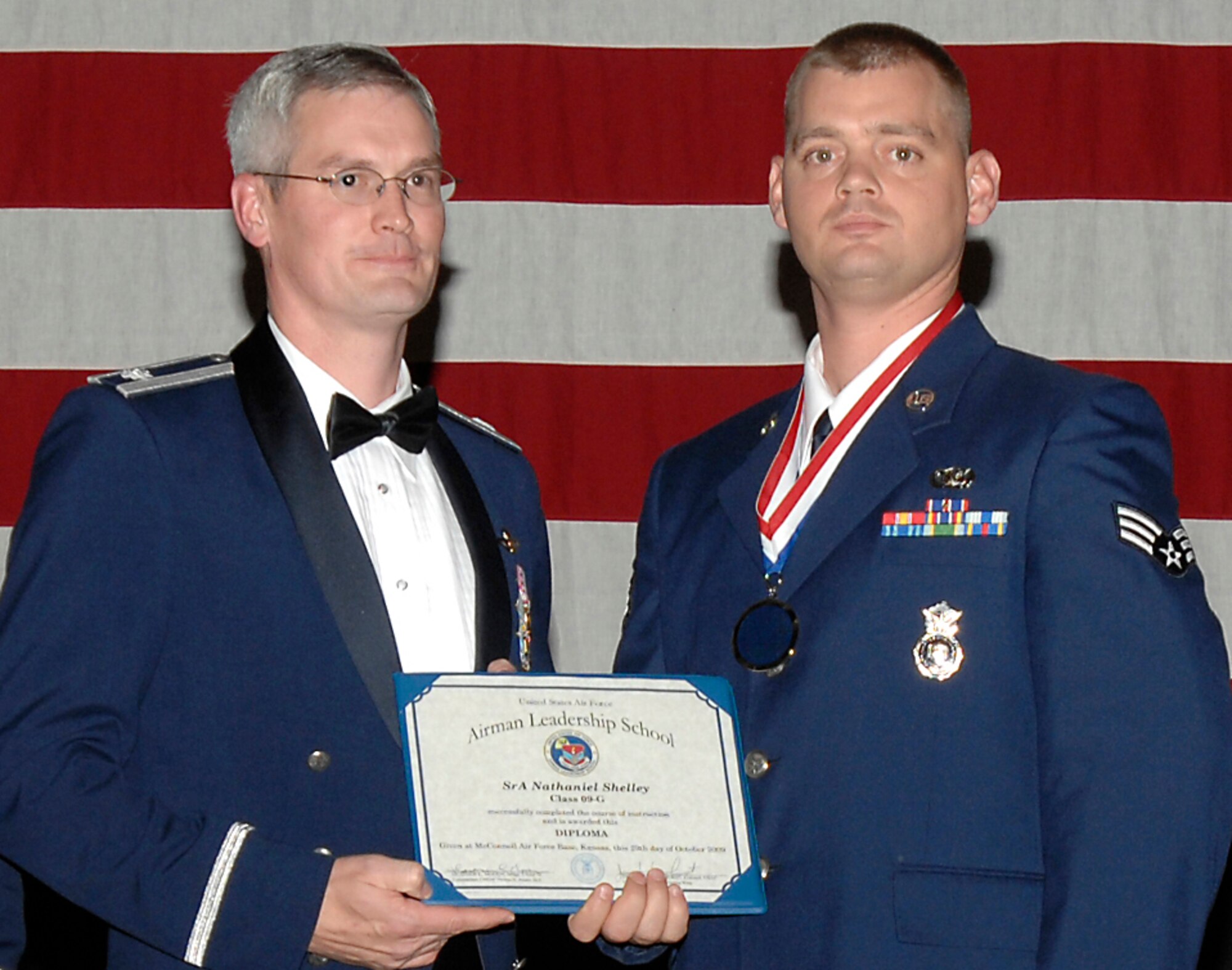 Senior Airman Nathan Shelley was one of three Reservists from the 931st Air Refueling Group who graduated Airman Leadership School during a ceremony at McConnell Air Force Base, Kan., on Oct. 29. Airman Shelley is a Reserve security forces member assigned to the 931st Mission Support Flight, an Air Force Reserve unit at McConnell. Also pictured (on left) is Lt. Col. Randall Sauer, acting 931st ARG vice commander. (U.S. Air Force photo/Senior Airman Laura Suttles)