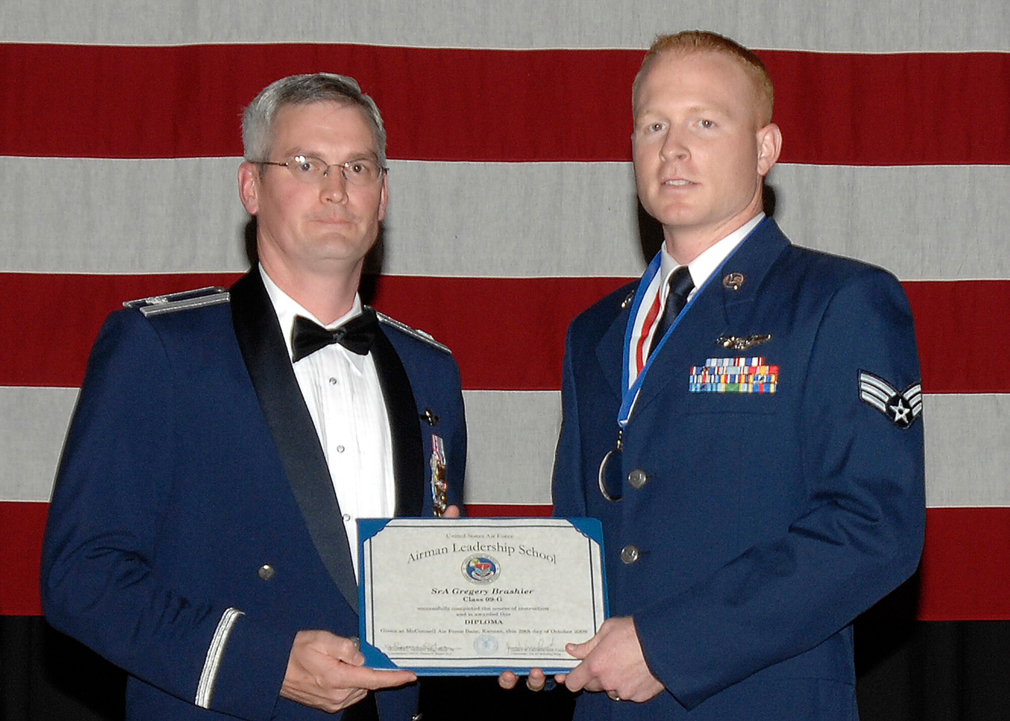 Senior Airman Gregery Brashier received a Distinguished Graduate Award during an Airman Leadership School graduation ceremony at McConnell Air Force Base, Kan., on Oct. 29. Airman Brashier is a Reserve inflight refueler assigned to the 18th Air Refueling Squadron, the flying unit of the 931st Air Refueling Group. Also pictured (on left) is Lt. Col. Randall Sauer, acting 931st ARG vice commander. (U.S. Air Force photo/Senior Airman Laura Suttles)