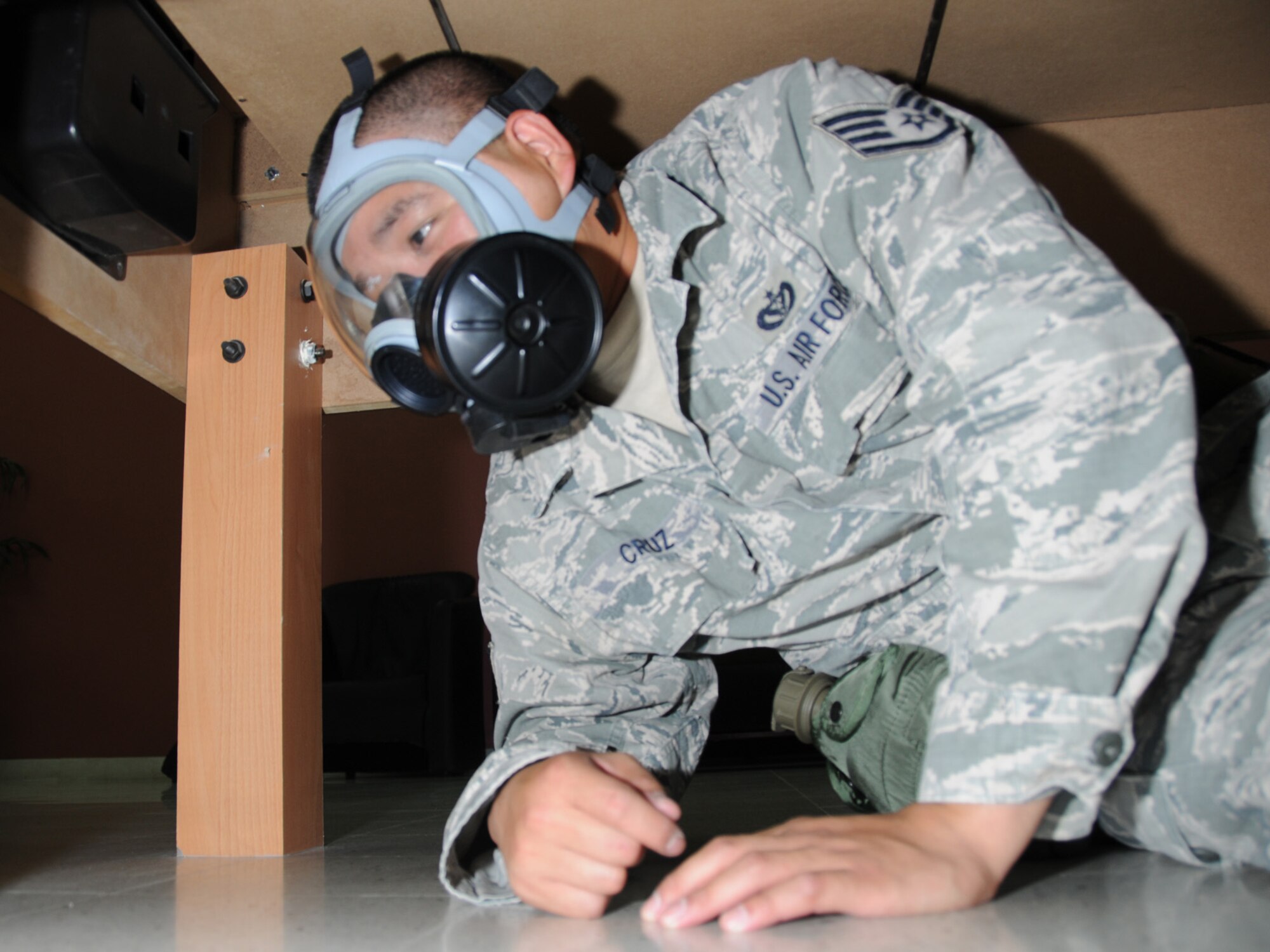 Staff Sgt. Allen Cruz, 379th Expeditionary Civil Engineer Squadron electrical systems journeyman, takes cover during a simulated attack at an undisclosed location in Southwest Asia, Nov. 3, 2009. Personnel assigned to the 379th Air Expeditionary Wing and other tenant units participate in exercises regularly to train on a variety of potential real-world scenarios. (U.S. Air Force Photo/Tech. Sgt. Jason W. Edwards)