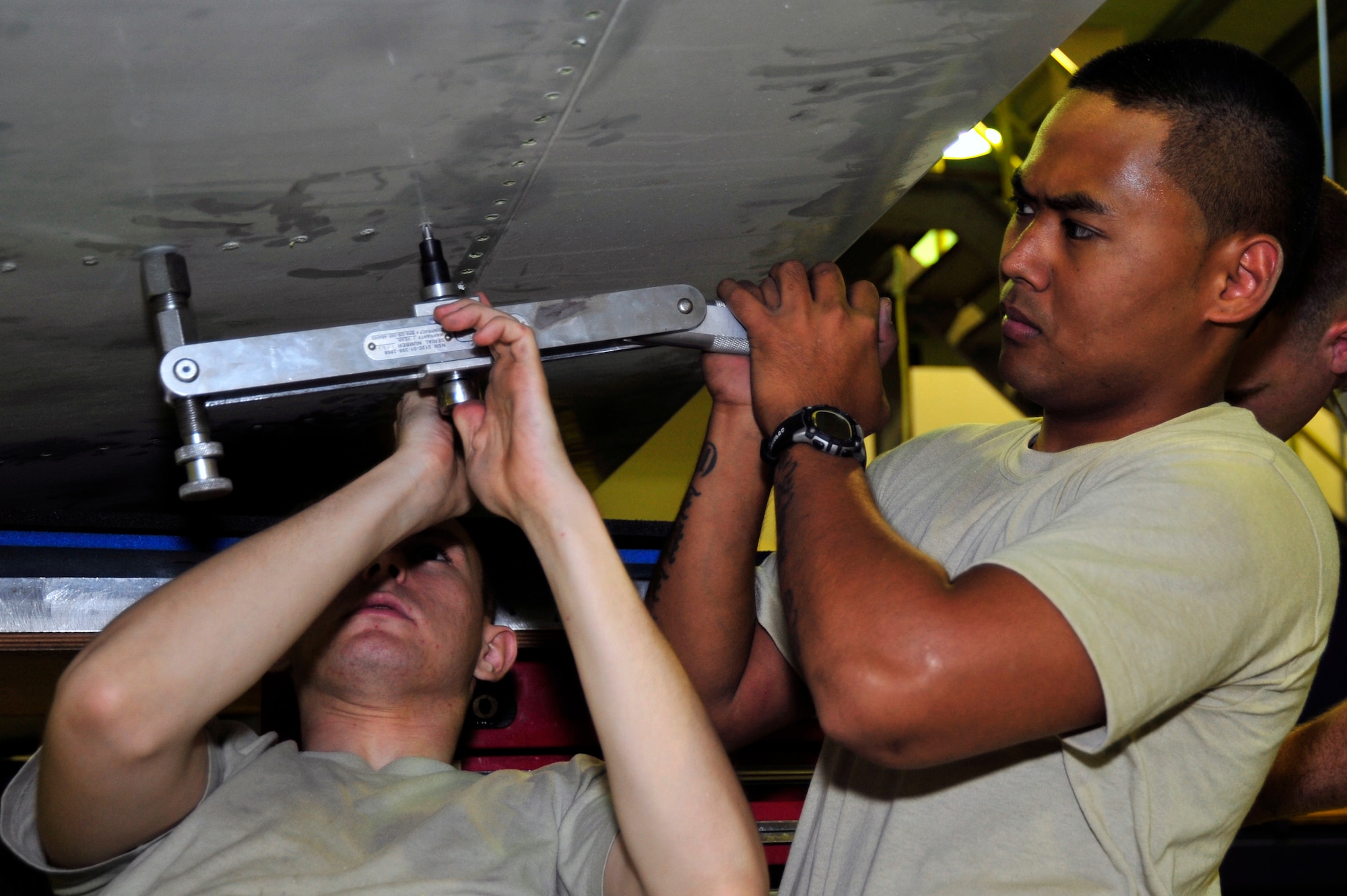 SOUTHWEST ASIA -Senior Airman Steven Villados assists Senior Airman Adam Steinman, 380th Expeditionary Aircraft Maintenance Squadron, with a removal of a
screw from a flight control surface Nov. 3, 2009. Airman Villados is currently deployed from Tinker Air Force Base, Okla., and grew up in Waipio, Hawaii. Airman Steinman is deployed from Beale Air Force Base, Calif., and hails from Sacramento, Calif. (U.S. Air Force photo/Tech. Sgt. Charles Larkin Sr)