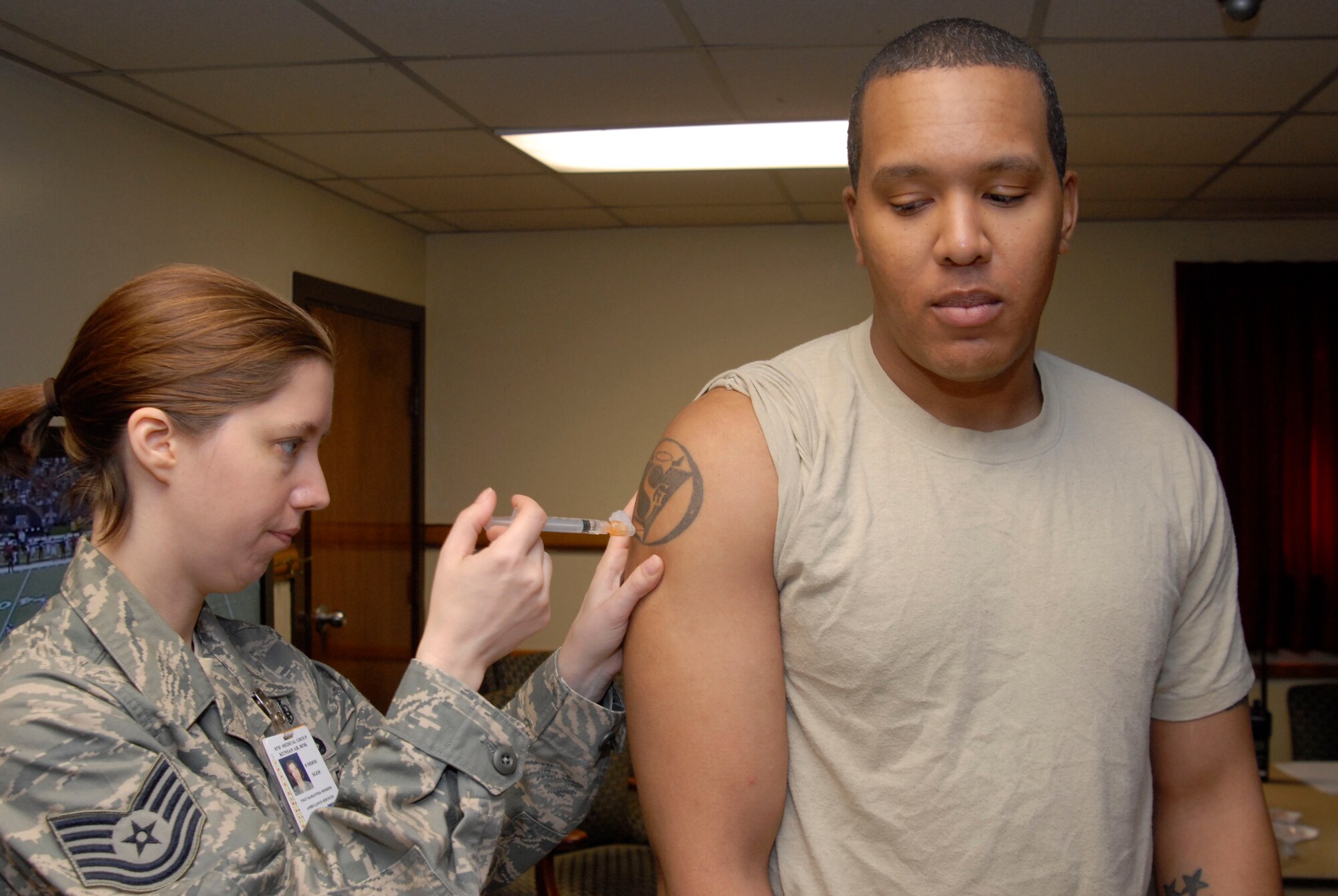 KUNSAN AIR BASE, Republic of Korea -- Tech. Sgt. Dominique Dickens, Armed Forces Network, receives the H1N1 flu vaccination from Tech. Sgt. Samantha Mosher, 8th Medical Gourp, during the first day of administrating the H1N1 flu vaccination here. This vaccination is mandatory for all active duty personnel. (U.S. Air Force photo/Staff Sgt. Darnell T. Cannady)