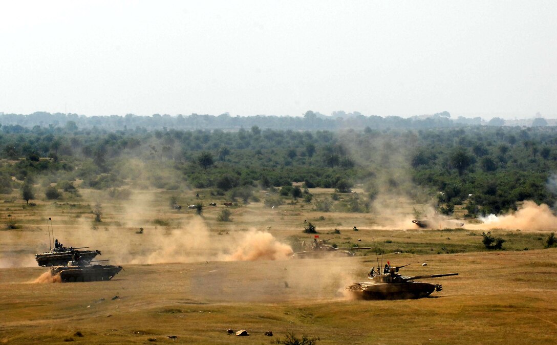 A mix of Indian army tanks and infantry vehicles onto the firing range at Camp Bundela, India Oct. 26, 2009. Soldiers from the 2nd Squadron, 14th Cavalry Regiment, based out of Hawaii traveled with 17 of their Strykers to India for two weeks to train with the India army. The final live-fire demonstration offered up both the conventional battlefield power of the Indian’s T-90 tanks with the high-technology precision of the U.S. military’s Javelin. 