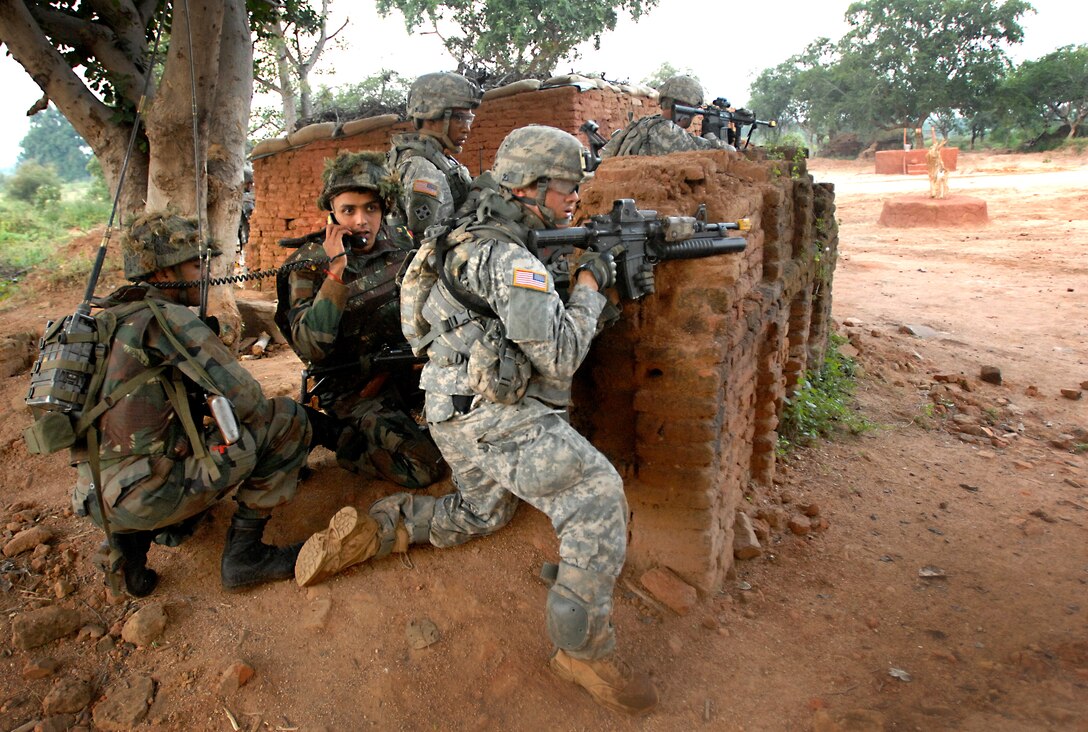 Indian and U.S. Army soldiers set up a perimeter around a village during a mock terrorist scenario Oct. 25, 2009 at Camp Bundela, India. Soldiers from each army were integrated down to the squad level throughout the course of the two-week exercise. 