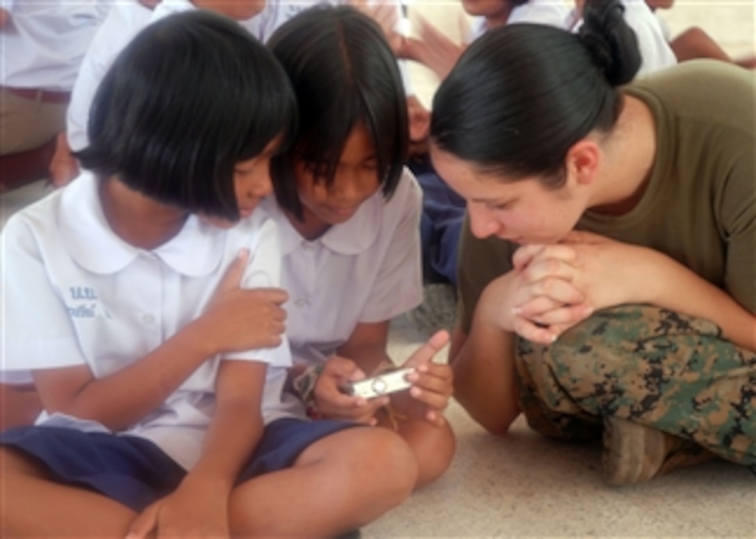 U.S. Marine Corps Lance Cpl. Julia Antonelli, assigned to the 11th Marine Expeditionary Unit embarked on the amphibious assault ship USS Bonhomme Richard (LHD 6), shows her camera to students at the Baan Bang Thong School in Phuket, Thailand, on Nov. 2, 2009.  Twenty-eight sailors and Marines from the Bonhomme Richard and the 11th Marine Expeditionary Unit participated in a community service project at the school, one of three projects during their port visit to Phuket.  The Bonhomme Richard Amphibious Ready Group is transiting the U.S. 7th Fleet area of operations.  