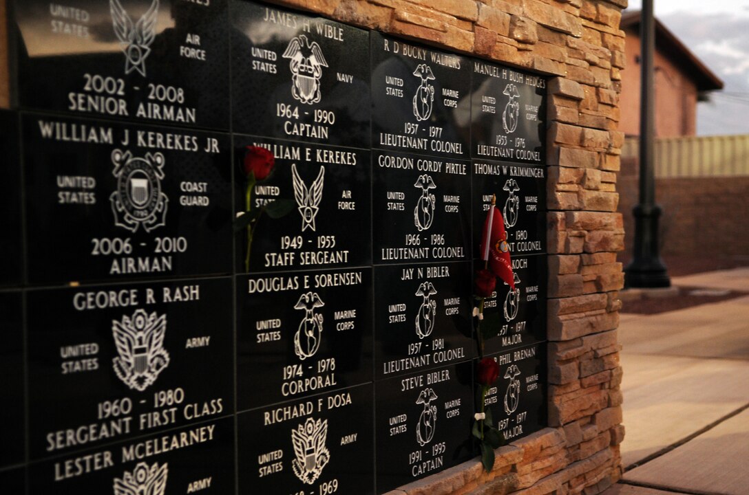 Granite plaques, commemorating a group of retired service members, were dedicated Nov. 4, 2009, at the Yuma Armed Forces Park, in Yuma, Ariz. The red roses affixed to three of the plaques are in memory of three group members who have passed away, and the Marine Corps flag represents the camaraderie formed while they served together at the Marine Corps Air Station in Yuma in the 1970s. They started going on regular hunting and camping trips with each other and their families in the Kofa National Wildlife Refuge, a tradition that has lasted for more than 35 years and now includes three generations.