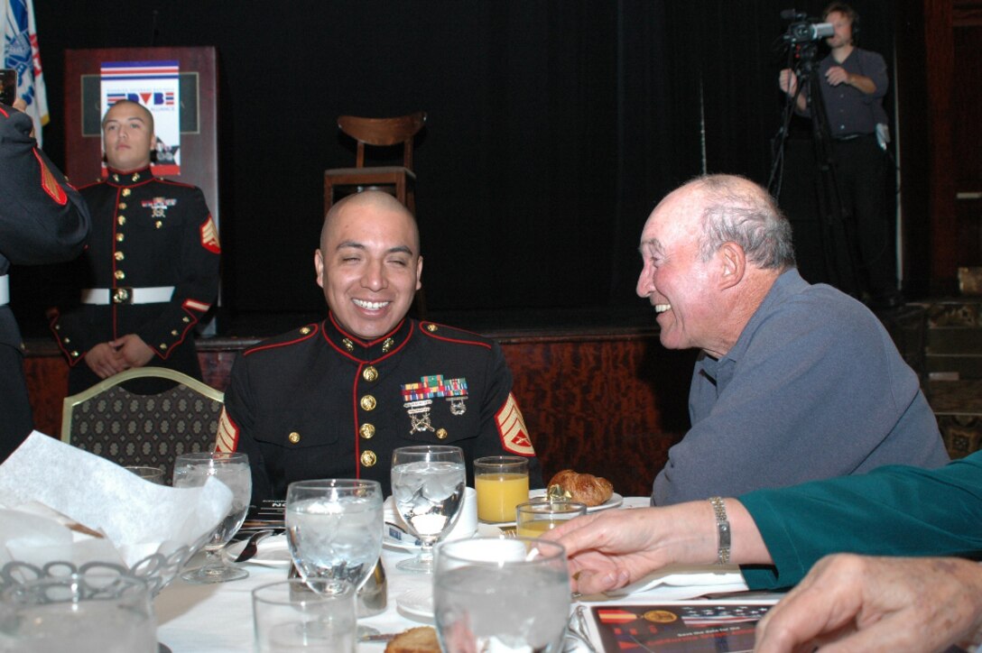 Staff Sgt. Nicolas Perez, a recruiter with Recruiting Station Los Angeles, laughs with actor Joe Santos at a Veterans Day breakfast hosted by the California Disabled Veterans Business Alliance, Nov. 6, in Los Angeles. The event brought past, present and future service members together.