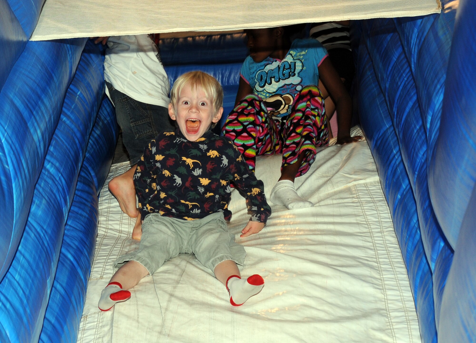 Matthew Goodner, 4, slips down an inflatable slide Nov. 2, 2009, at the youth center during the annual Family Fun and Feast at McConnell Air Force Base, Kan. The two-hour event provided hamburgers, hotdogs, drinks, snacks and activities for Team McConnell families. More than 300 people attended this year’s event. (U.S. Air Force photo/Staff Sgt. Amanda Currier)