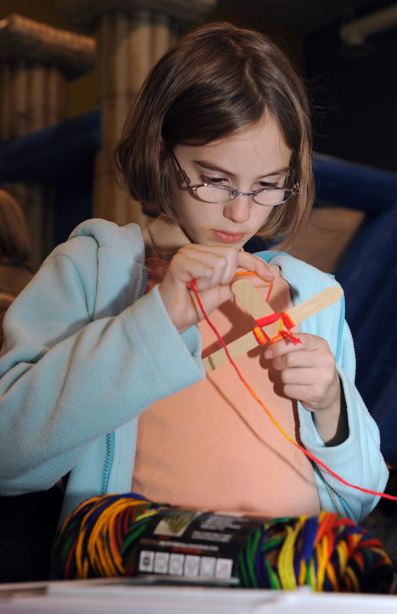 Emma Chastain, 9, a 22nd Civil Engineer Squadron family member, makes a God’s eye out of Popsicle sticks and yarn Nov. 2, 2009, at the youth center during the annual Family Fun and Feast at McConnell Air Force Base, Kan. Representatives from the base chapel, Airman and Family Readiness Center and Family Advocacy Program had activity and information booths at the event. (U.S. Air Force photo/Staff Sgt. Amanda Currier)