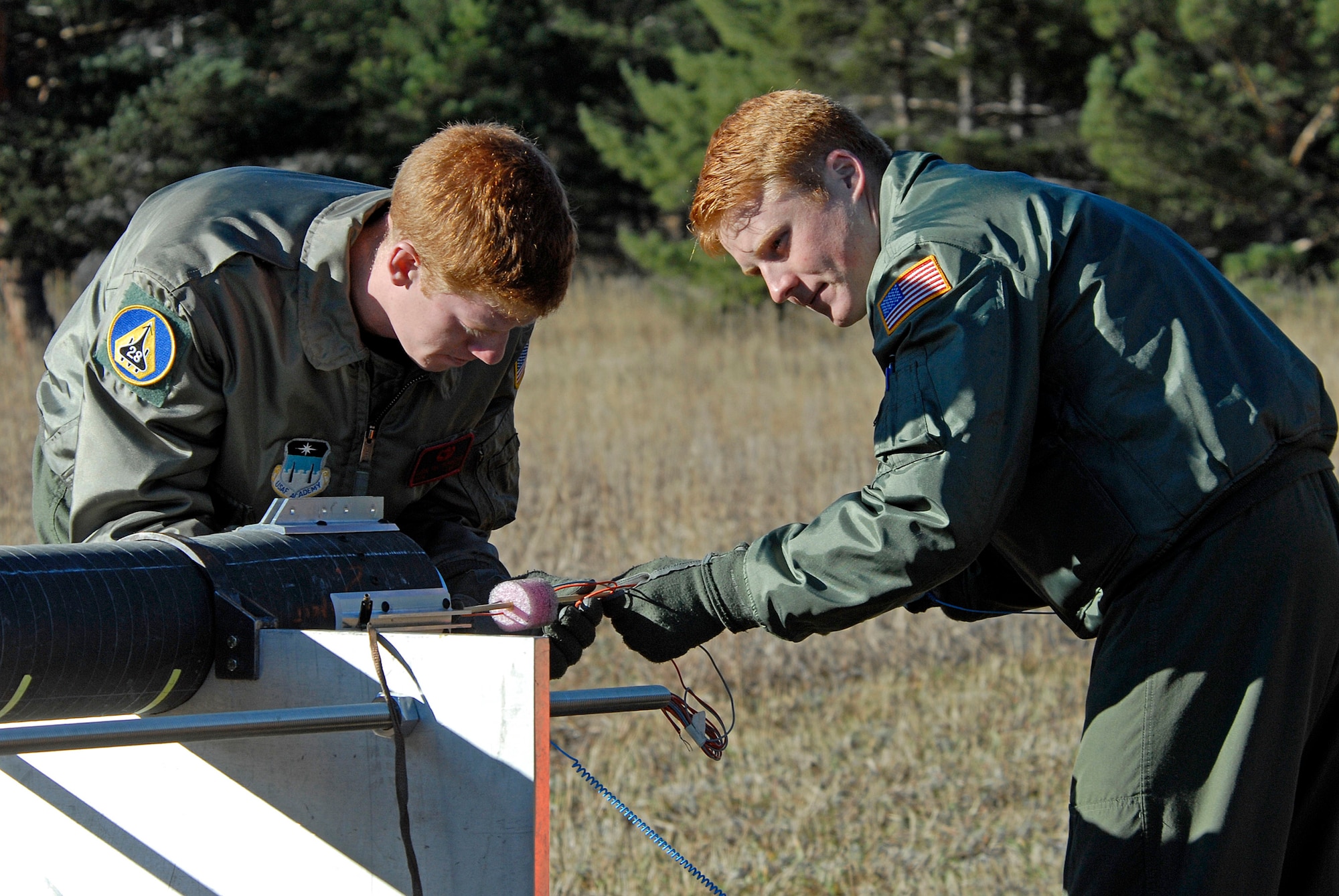 Cadets 1st Class Daniel Richardson and Sean Foote prepare FalconLaunch 6 for a static test fire in Jacks Valley at the U.S. Air Force Academy, Colo., Nov. 4, 2009. The rocket exploded a fraction of a second into the test firing, leaving cadets to determine the cause of the malfunction. (U.S. Air Force photo/Mike Kaplan)