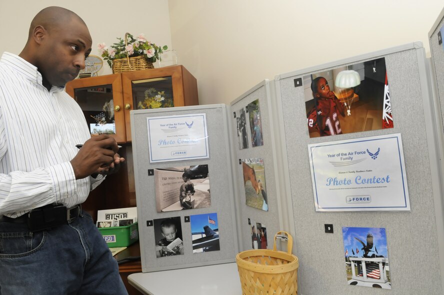 Torrance McGee selects his picks for winners in the Year of the Air Force Family photo exhibit at the Airman & Family Readiness Center Nov.5. U. S. Air Force photo by Sue Sapp
