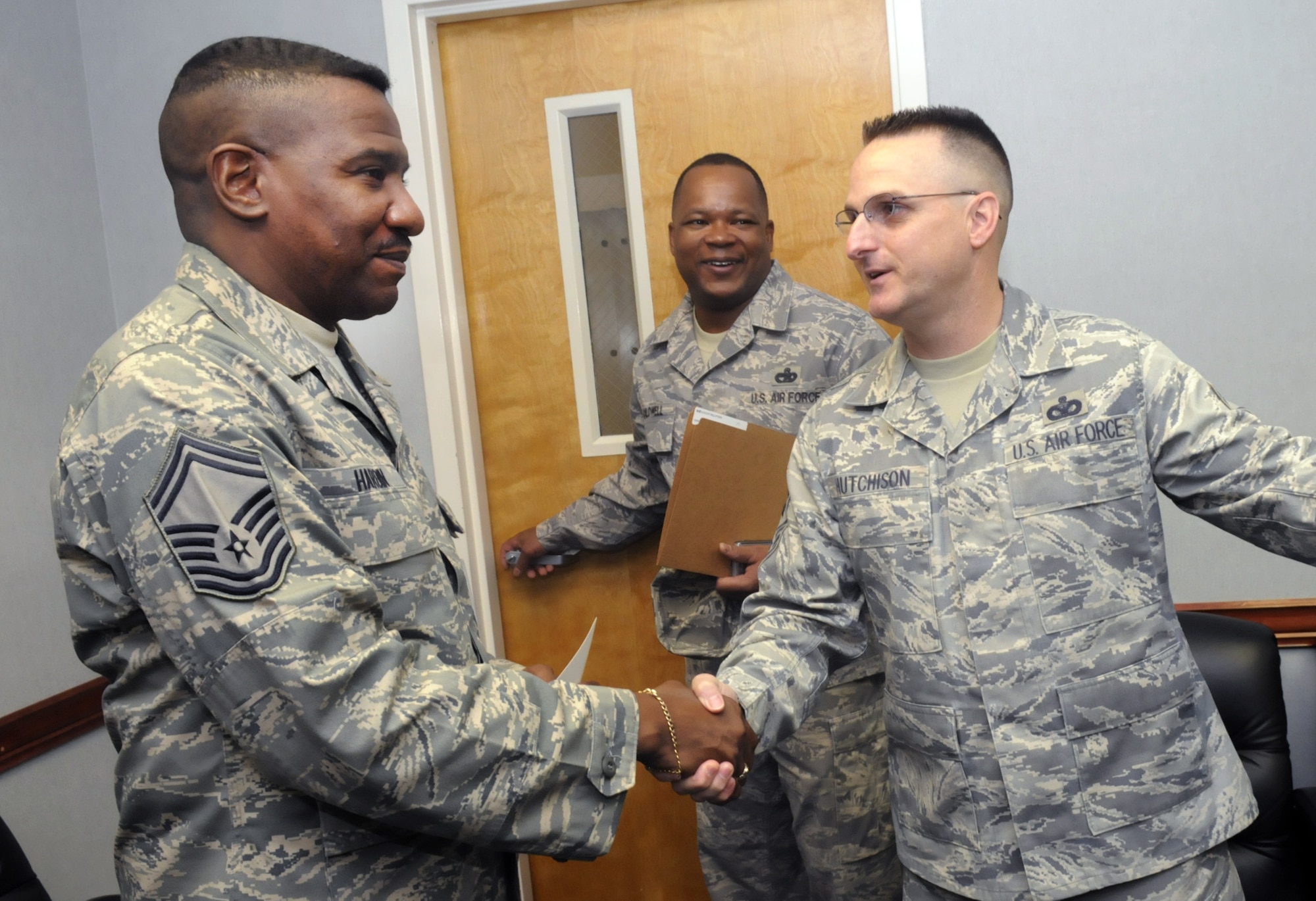 L-R, Senior Master Sergeant Wesley L. Hardin, 78th Medical Support Squadron, is congratulated by CMSgt. Otis Caldwell, Robins Chiefs Groups president, and 78th Air Base Wing Command Chief Master Sergeant Harold "Buddy" Hutchison in a surprise visit Nov. 5. Members of the Robins Chiefs Group along with Chief Hutchison and Col. Lee-Ann Perkins, 78th FSS commander, boarded a bus to make the rounds to congratulate members of Robins who made the Chief promotion list Nov. 5. Other promotees are Keith D. Davis, Jr., 78th Security Forces Squadron, Lori A. Gawan, 78th Logistics Readiness Squadron, Phillip G. Gawan, HQ Air Force Reserve, Gregory C. Joy, 116th Maintenance Group, and Wanda Y. Lee, 116th Maintenance Squadron. U. S. Air Force photo by Sue Sapp