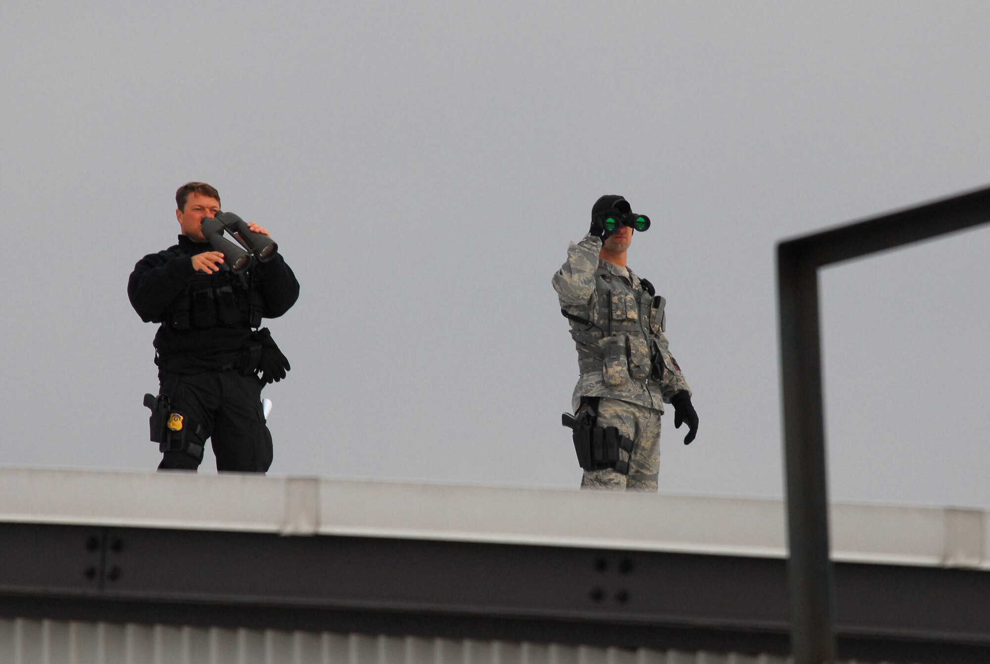 Staff Sgt. Anthony Rook (right), security forces member at the 115th Fighter Wing in Madison, Wis., along with a Secret Service agent scan for potential threats prior to and during a presidential visit Nov. 4, 2009.  President Barack Obama landed at the Air National Guard base on his way to give a speech at Madison's James Wright middle school about education reform.  President Obama's visit marks the first time that a sitting president has visited the base. (U.S. Air Force Photo by Master Sgt. Dan Richardson)
