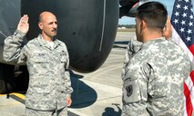 DUKE FIELD, Fla. -- With a 919th Special Operations Wing MC-130E Combat Talon I aircraft as his backdrop, Air Force Reserve Chief Master Sgt. Paul Albini (left) repeats the oath of enlistment given Nov. 2 by his son, Army 1st Lt. Nicholas Albini, a Headquarters Battery Executive officer stationed at Fort Hood, Texas. This was Chief Albini’s final enlistment ceremony in the Air Force Reserve which will carry him to his retirement after 38 years of service. Chief Albini, 919th Maintenance Squadron munitions section NCOIC, has been in service at Duke Field since 1984. (U.S. Air Force Photo/Staff Sgt. Jon McCallum)