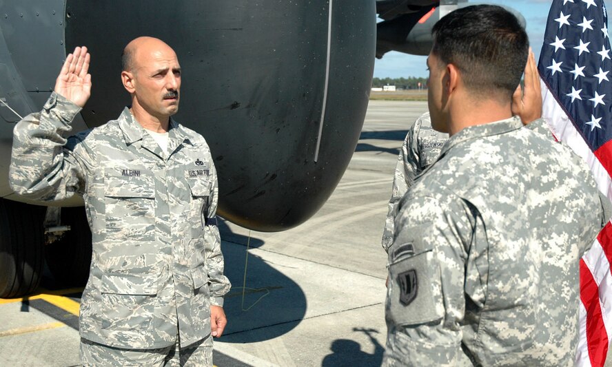 DUKE FIELD, Fla. -- With a 919th Special Operations Wing MC-130E Combat Talon I aircraft as his backdrop, Air Force Reserve Chief Master Sgt. Paul Albini (left) repeats the oath of enlistment given Nov. 2 by his son, Army 1st Lt. Nicholas Albini, a Headquarters Battery Executive officer stationed at Fort Hood, Texas. This was Chief Albini’s final enlistment ceremony in the Air Force Reserve which will carry him to his retirement after 38 years of service. Chief Albini, 919th Maintenance Squadron munitions section NCOIC, has been in service at Duke Field since 1984. (U.S. Air Force Photo/Staff Sgt. Jon McCallum)