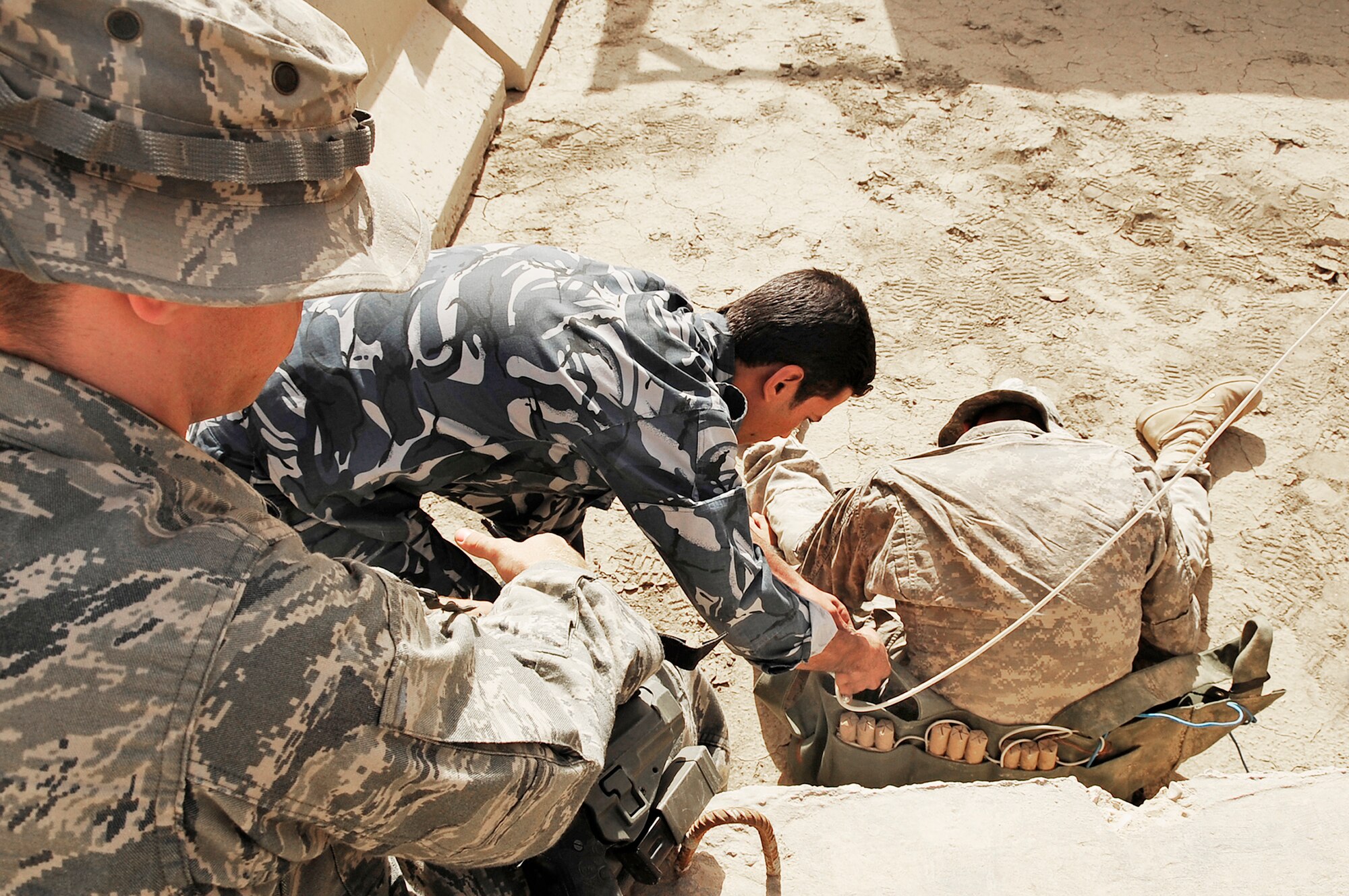 Senior Airman Kyle Gnuechtel observes and advises Iraqi police explosive ordnance disposal technicians as they safely remove a suicide bomber's vest during a training scenario conducted by Air Force EOD members Nov. 4, 2009, at Forward Operating Base Cedar, Iraq. Airman Gnuechtel is a 407th Expeditionary Civil Engineer Squadron EOD technician deployed from Dyess Air Force Base, Texas. (U.S. Air Force photo/Senior Airman Tony R. Ritter) 
