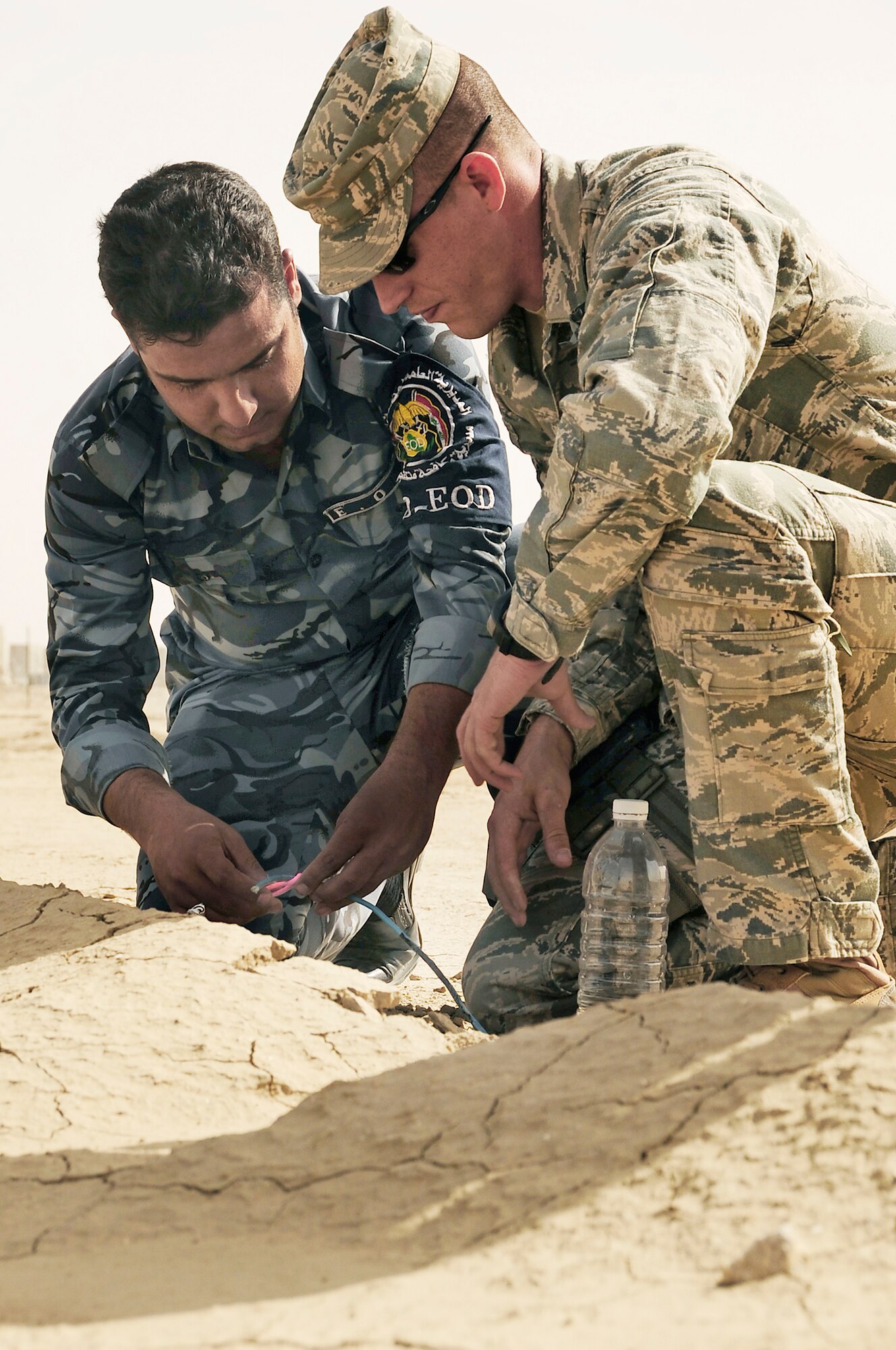 Staff Sgt. Arthur Bigelow advises an Iraqi police explosive ordnance disposal technician as he inerts an improvised explosive device during a training scenario conducted by Air Force EOD members Nov. 4, 2009, at Forward Operating Base Cedar, Iraq. Sergeant Bigelow is a 407th Expeditionary Civil Engineer Squadron EOD technician deployed from Fairchild Air Force Base, Wash. (U.S. Air Force photo/Senior Airman Tony R. Ritter) 