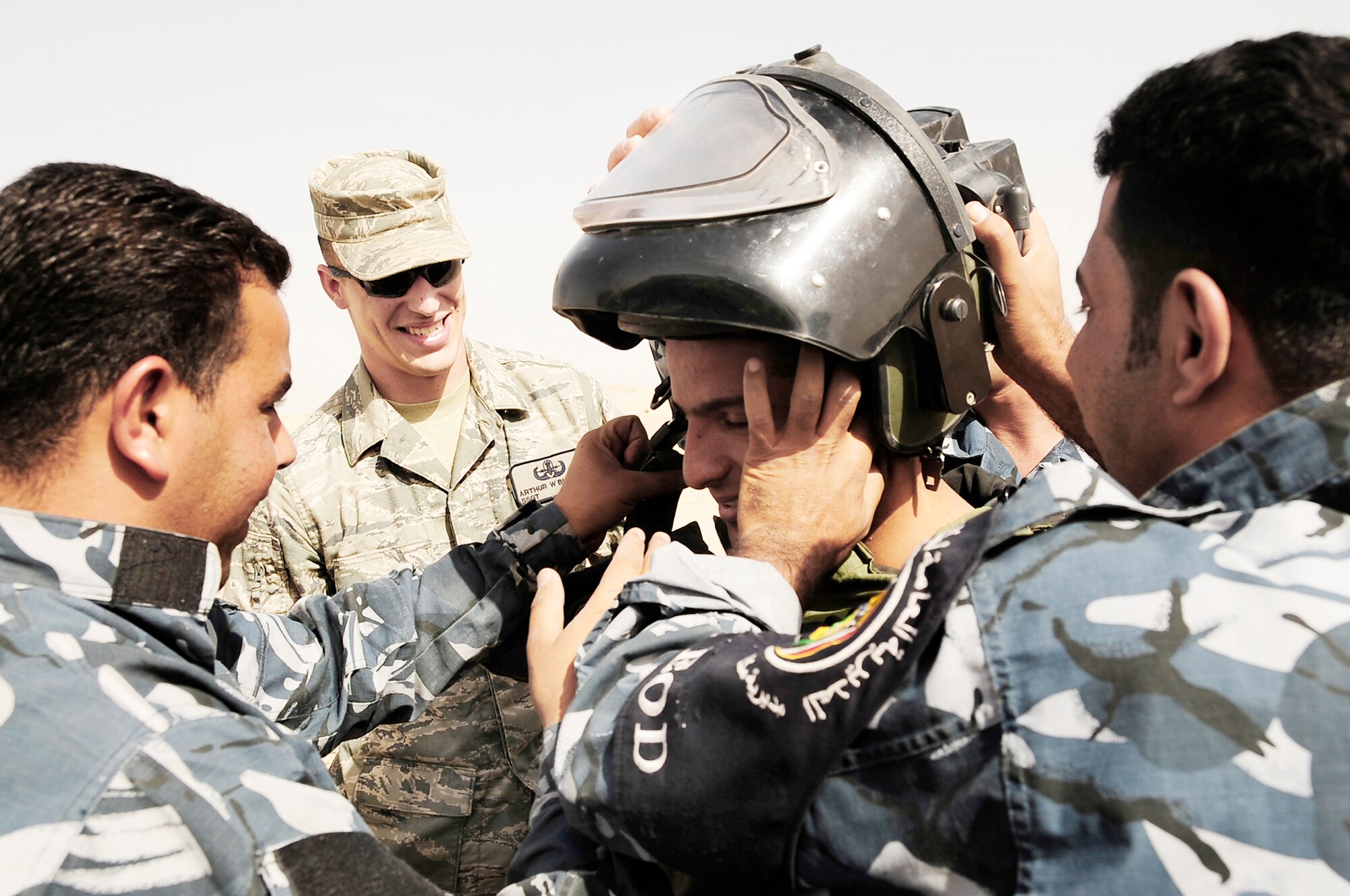 Staff Sgt. Arthur Bigelow assists Iraqi police explosive ordnance disposal technicians get a team member into a bomb suit during a training scenario conducted by Air Force EOD members Nov. 4, 2009, at Forward Operating Base Cedar, Iraq. Sergeant Bigelow is a 407th Expeditionary Civil Engineer Squadron EOD technician deployed from Fairchild Air Force Base, Wash. (U.S. Air Force photoSenior Airman Tony R. Ritter) 