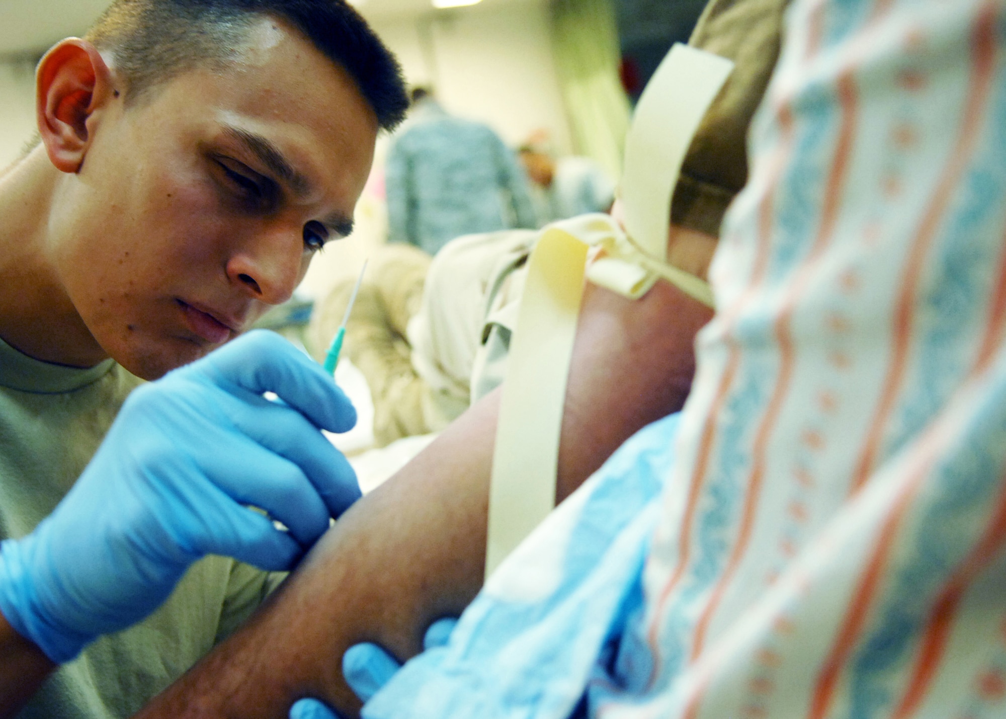 JOINT BASE BALAD, Iraq -- Staff Sgt. Christopher Hipsher, 332nd Expeditionary Communications Squadron small computer technician, prepares to administer intravenous fluids to a patient at the Air Force Theater Hospital here Oct. 22, 2009. Sergeant Hipsher is an emergency medical technician volunteer and is state certified in Hawaii. (U.S. Air Force photo/ Senior Airman Christopher Hubenthal)