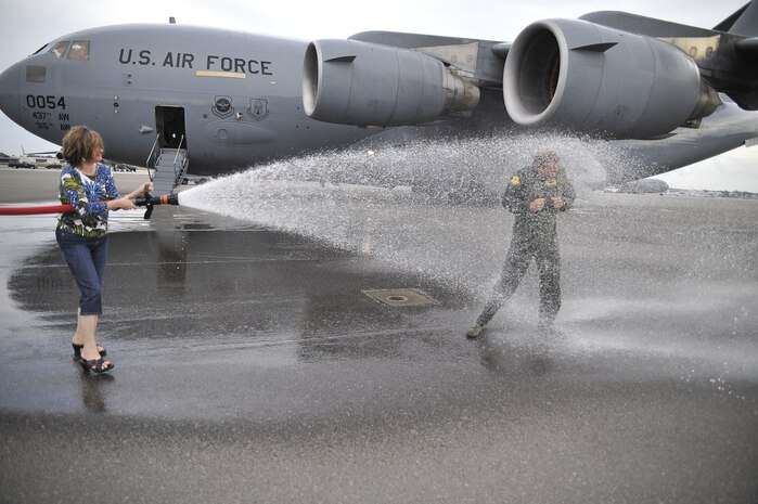 Debbie Shaffer gives Col. Don Shaffer a thorough soaking after flying a Charleston AFB C-17 for his final time as the 437th Airlift Wing vice commander. Colonel Shaffer and his wife plan to depart Charleston AFB Nov. 7 for a new assignment in Grand Forks, N.D., where the colonel will take command of the 319th Air Refueling Wing. (U.S. Air Force photo/James Bowman)