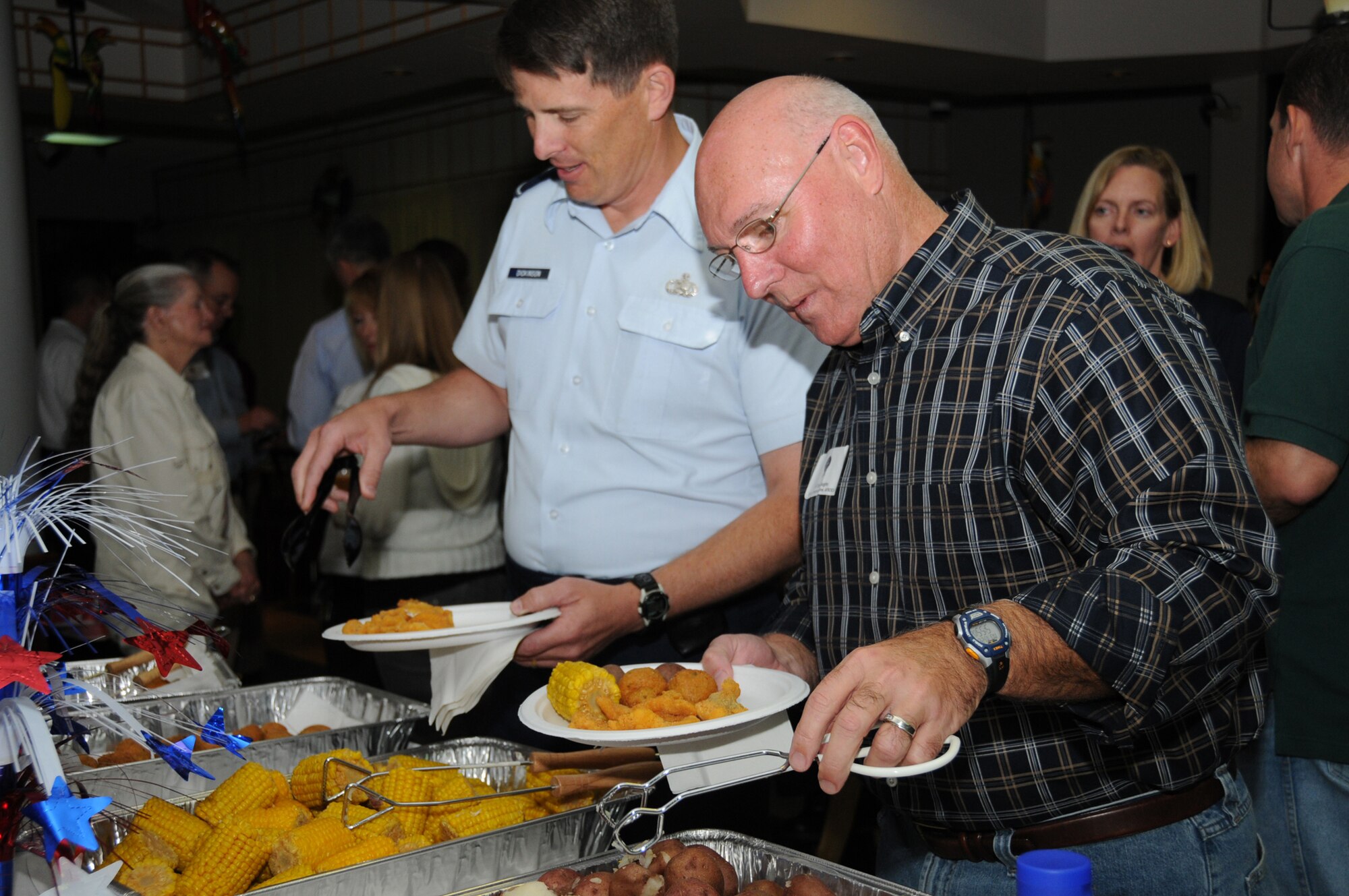 Brig. Gen. Ian Dickinson, left, 81st Training Wing commander, and Col. Tony Faughn, director of communications for Air Force Special Operations Command at Hurlburt Field, Fla., fill their plates at the Scope Warrior fish fry at the Katrina Kantina, Oct. 26.  Keesler hosts the annual Scope Warrior worldwide conference for the Air Force’s senior communications and information leaders to discuss current communications issues and plan future initiatives.  (U.S. Air Force photo by Kemberly Groue)