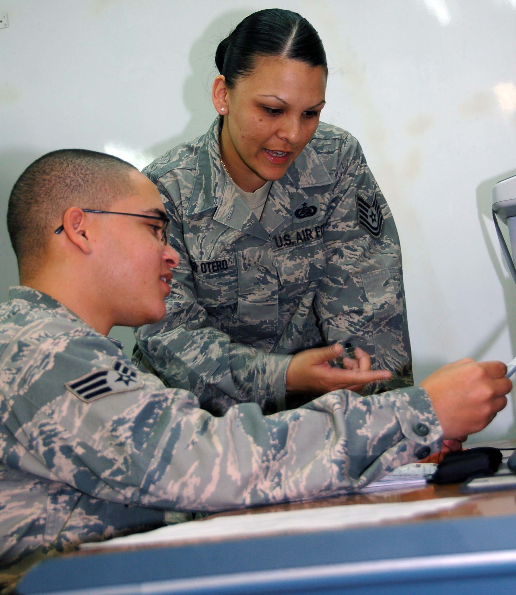Senior Airman Cahill (sitting), Supply customer service specialist with the 376th Expeditionary Logistics Readiness Squadron, tracks parts to be disturbed to various organizations here with Tech. Sgt. Angela Santiago using the delinquency document list at the Transit Center at Manas. The customer service section works together with the warehouse to meet supply needs of Airmen and coalition forces at the Transit Center. Airman Cahill is deployed to the 376th ELRS from RAF Lakenheath, United Kingdom.