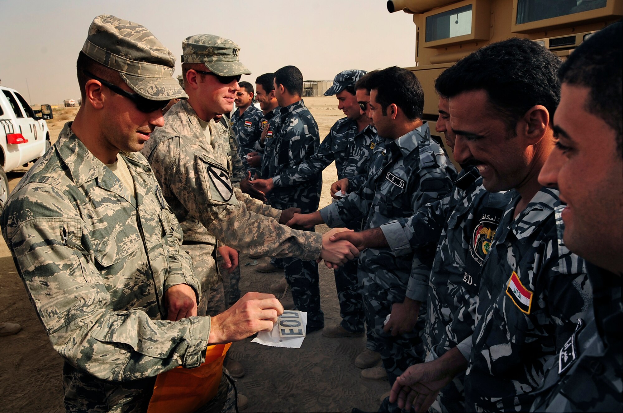 FORWARD OPERATING BASE CEDAR, Iraq -- U.S. Air Force Staff Sgt. Jonathan Quast, explosive ordinance disposal (EOD) technician, 407th Expeditionary Civil Engineer Squadron, gives Iraqi Police EOD technicians their EOD patches upon completion of several hours of training conducted by the Air Force EOD members here, Nov. 4, 2009. The training was a part of a six week course offered to the Iraqi Police to better help them understand the technicalities of EOD that would further aid in the transition of troops scheduled to withdraw from Iraq in 2011.  Sergeant Quast is deployed here from McDill Air Force Base, Fla. (U.S. Air Force photo by Senior Airman Tony R. Ritter)