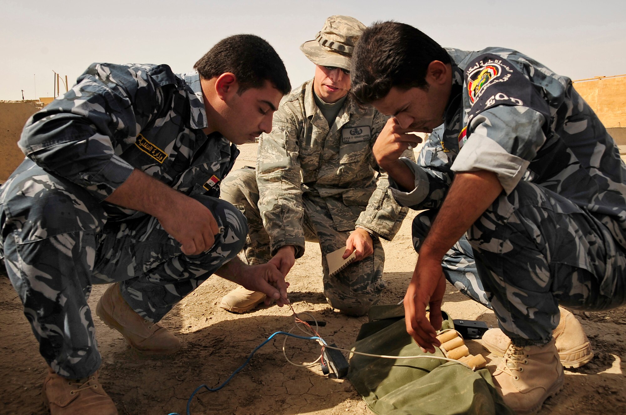 FORWARD OPERATING BASE CEDAR, Iraq -- U.S. Air Force Senior Airman Kyle Gnuechtel, explosive ordinance disposal (EOD) technician, 407th Expeditionary Civil Engineer Squadron, advises Iraqi Police EOD technicians as they inert a suicide bomber’s vest during a training scenario conducted by the Air Force EOD members here, Nov. 4, 2009. The training was a part of a six week course offered to the Iraqi Police to better help them understand the technicalities of EOD that would further aid in the transition of troops scheduled to withdraw from Iraq in 2011.  Airman Gnuechtel is deployed here from Dyess Air Force Base, Texas. (U.S. Air Force photo by Senior Airman Tony R. Ritter)

