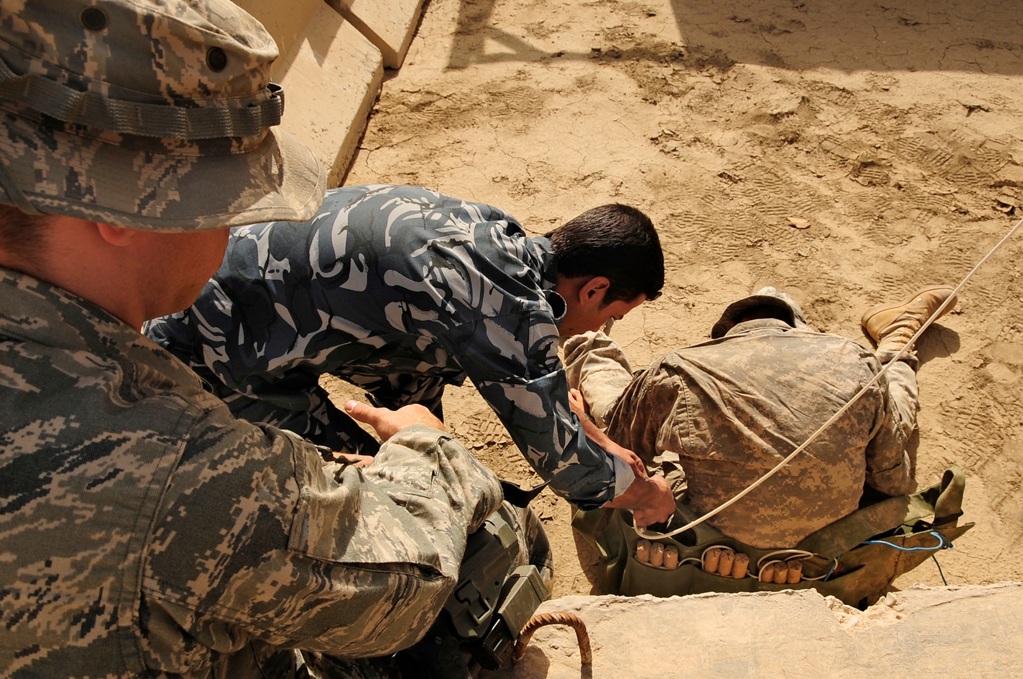 FORWARD OPERATING BASE CEDAR, Iraq -- U.S. Air Force Senior Airman Kyle Gnuechtel, explosive ordinance disposal (EOD) technician, 407th Expeditionary Civil Engineer Squadron, observes and advises Iraqi Police EOD technicians as they safely remove a suicide bomber’s vest during a training scenario conducted by the Air Force EOD members here, Nov. 4, 2009. The training was a part of a six week course offered to the Iraqi Police to better help them understand the technicalities of EOD that would further aid in the transition of troops scheduled to withdraw from Iraq in 2011. Airman Gnuechtel is deployed here from Dyess Air Force Base, Texas. (U.S. Air Force photo by Senior Airman Tony R. Ritter)
